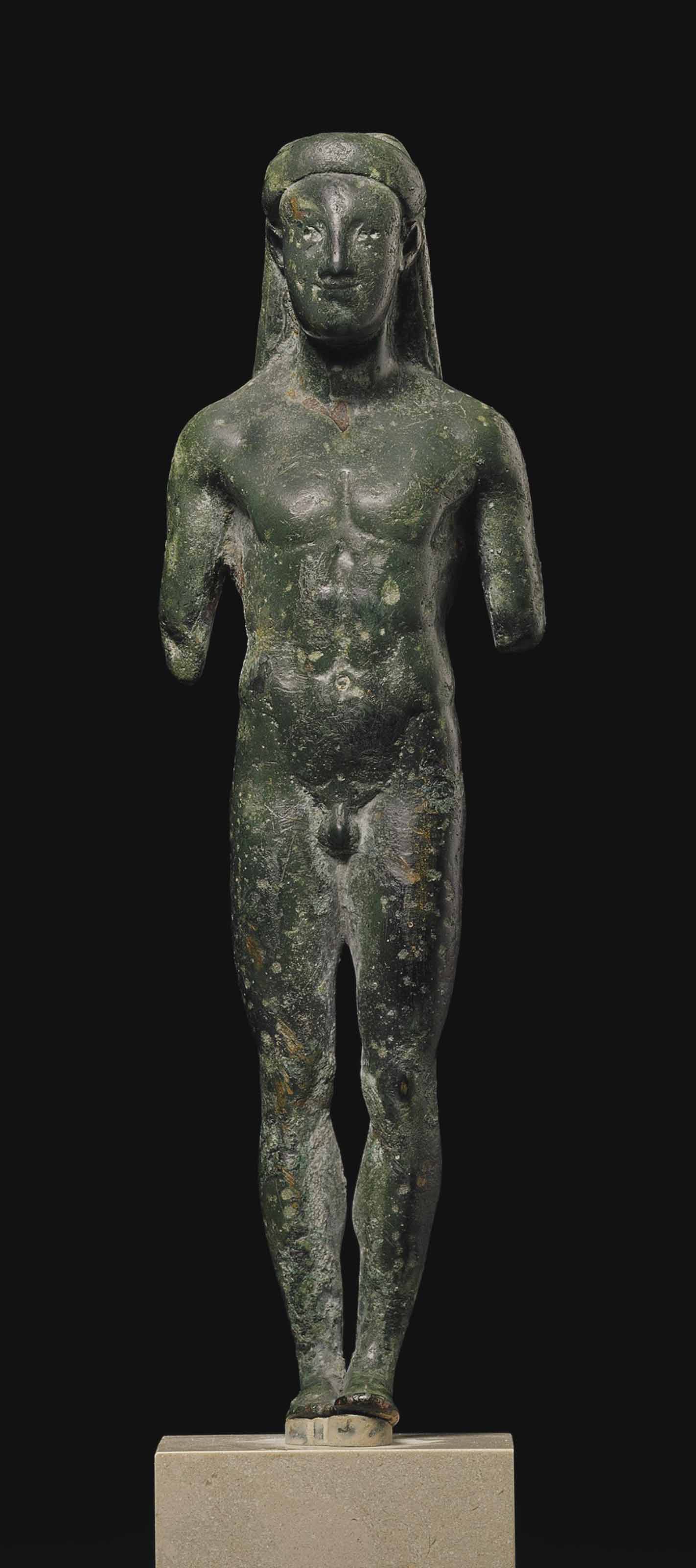 A GREEK BRONZE KOUROS , ARCHAIC PERIOD, CIRCA LATE 6TH CENTURY B.C