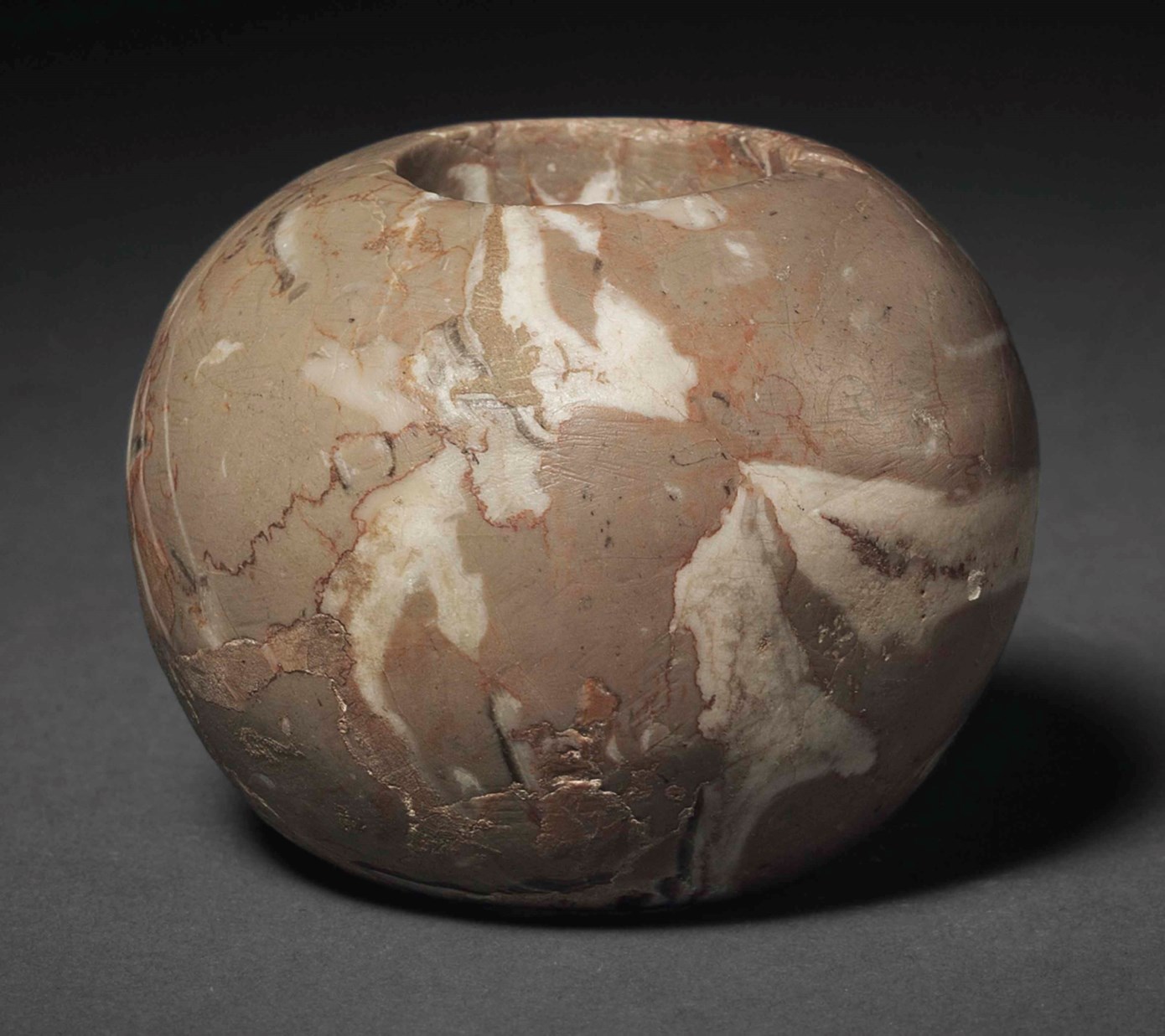 AN EGYPTIAN BRECCIATED LIMESTONE MACE HEAD