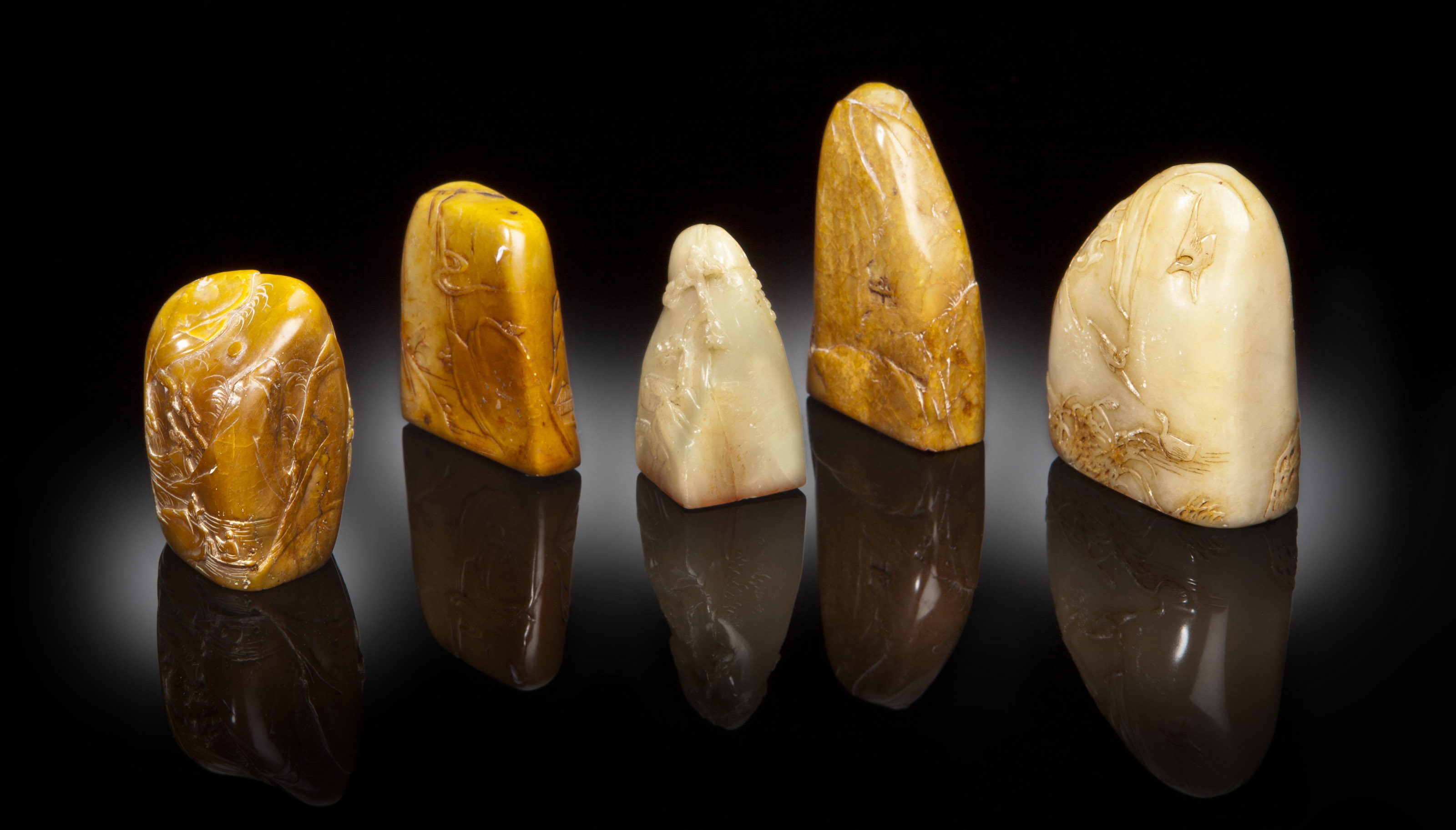 A GROUP OF TWO SOAPSTONE MOUNTAINFORM SEALS AND THREE SOAPSTONE