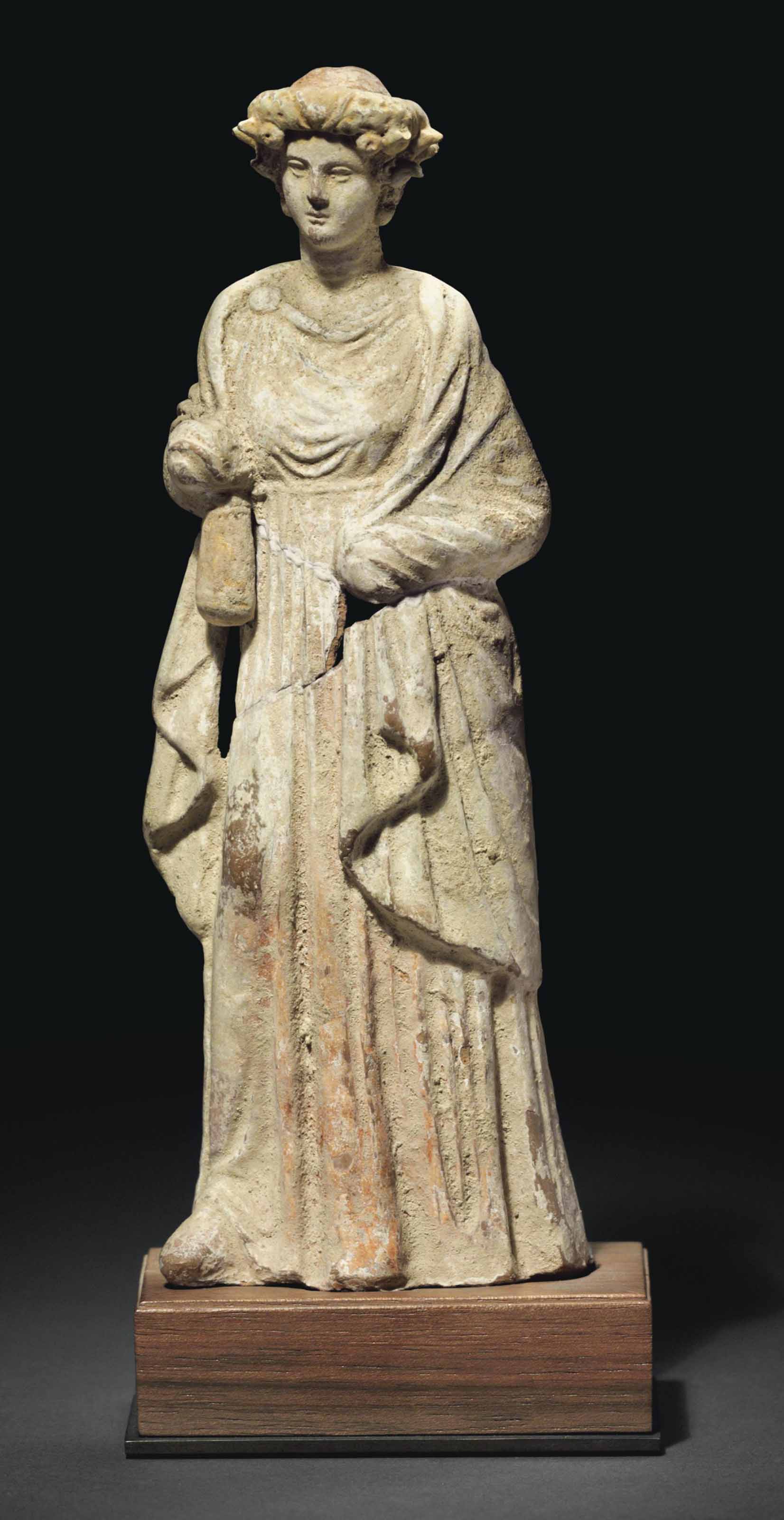 A GREEK TERRACOTTA DRAPED FEMALE FIGURE , HELLENISTIC PERIOD, CIRCA 3RD