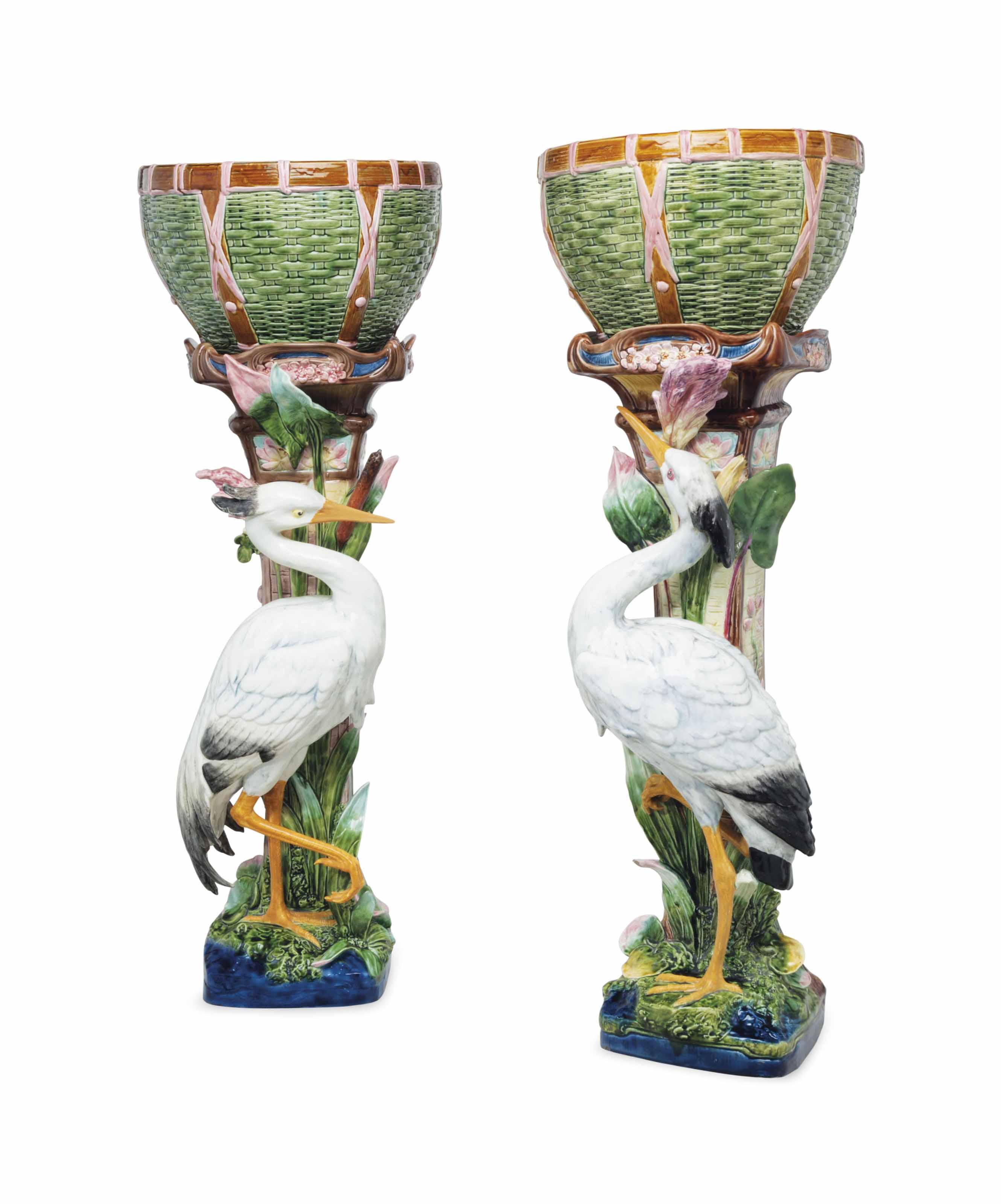 A PAIR OF CONTINENTAL MAJOLICA JARDINIERES AND CRANE PEDESTALS , LATE