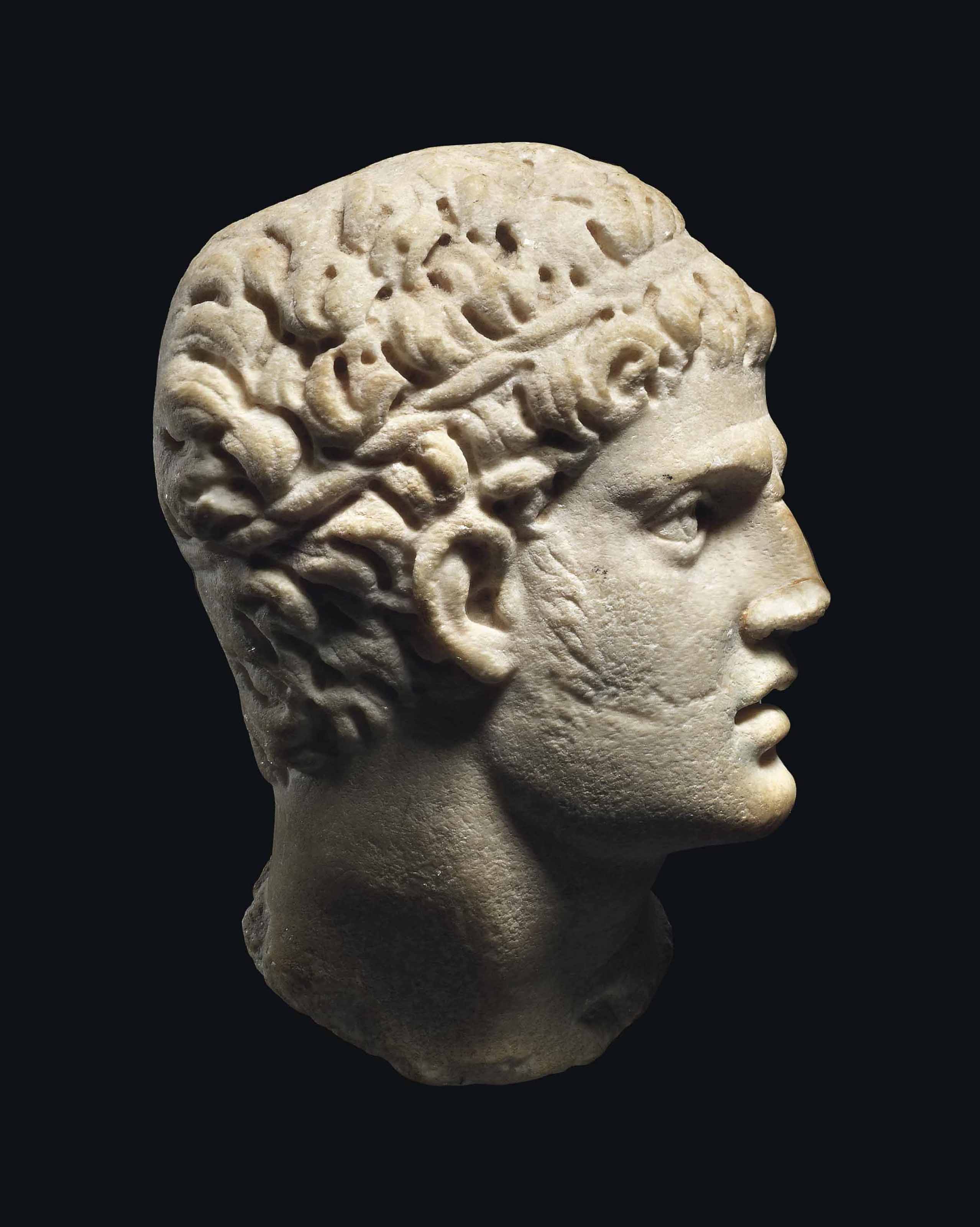 A ROMAN MARBLE RELIEF HEAD OF MELEAGER , CIRCA 2ND CENTURY A.D
