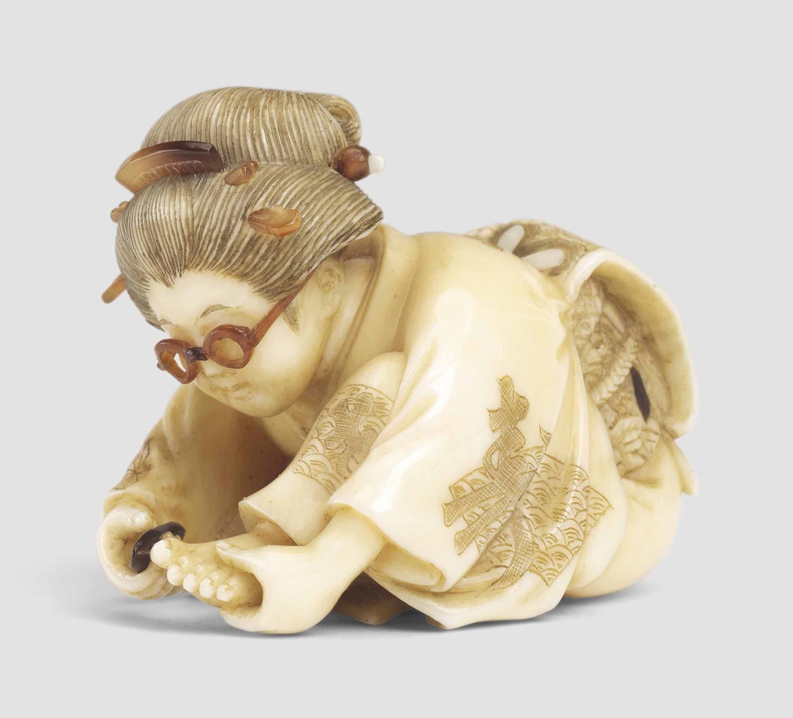 An Ivory Netsuke Of A Woman Cutting Her Toenails