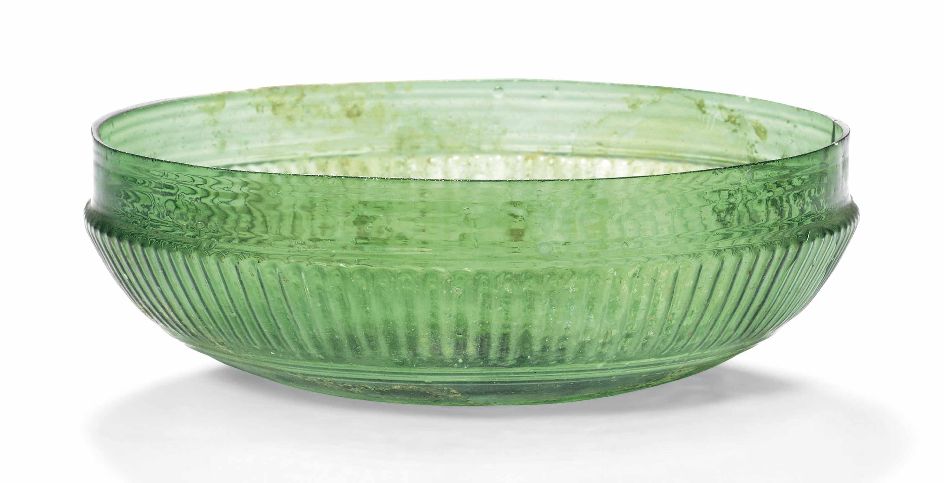 A ROMAN EMERALD GREEN GLASS RIBBED BOWL