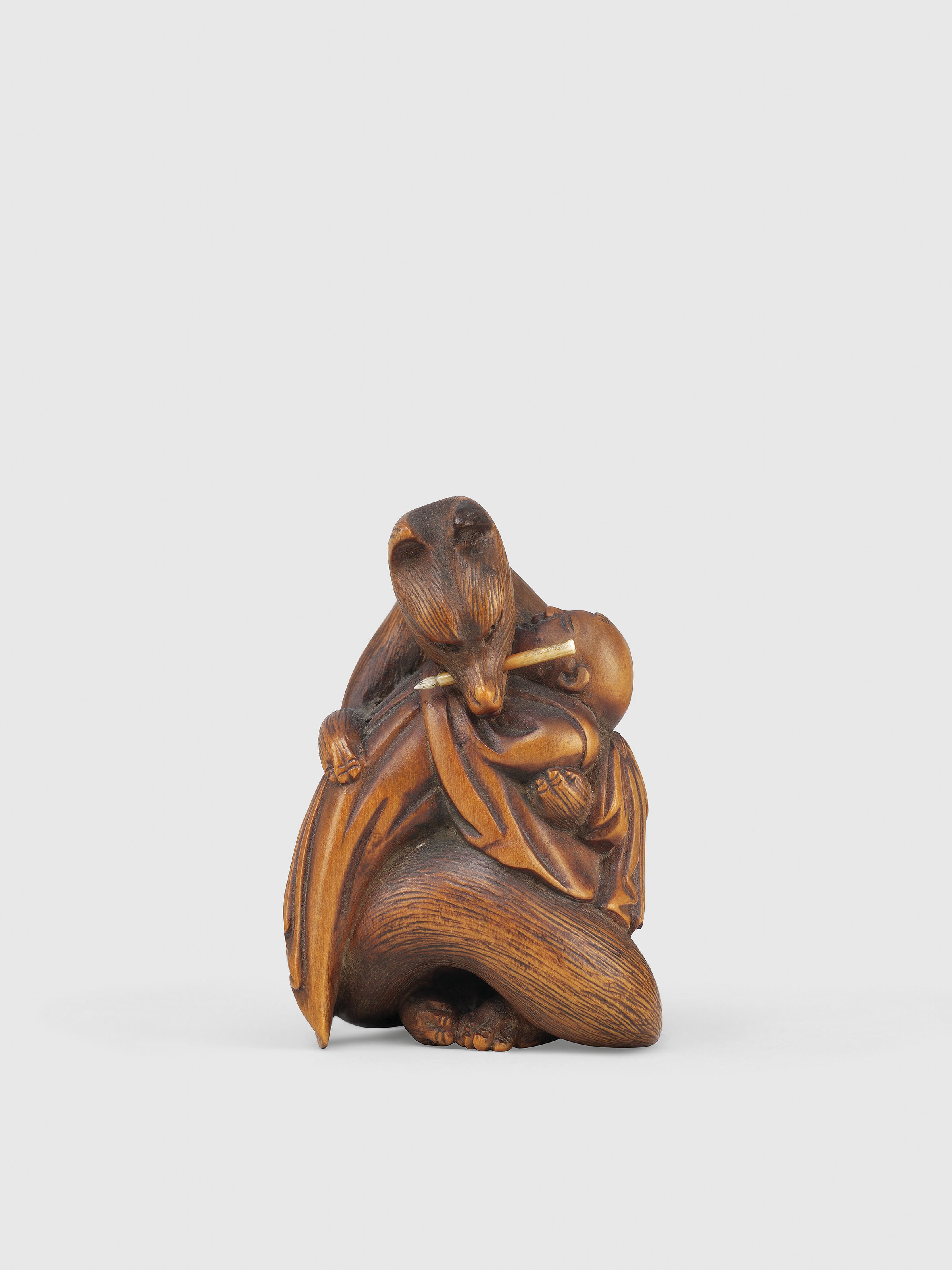 A WOOD NETSUKE OF THE FOX WIFE KUZUNOHA, EDO PERIOD (19TH CENTURY
