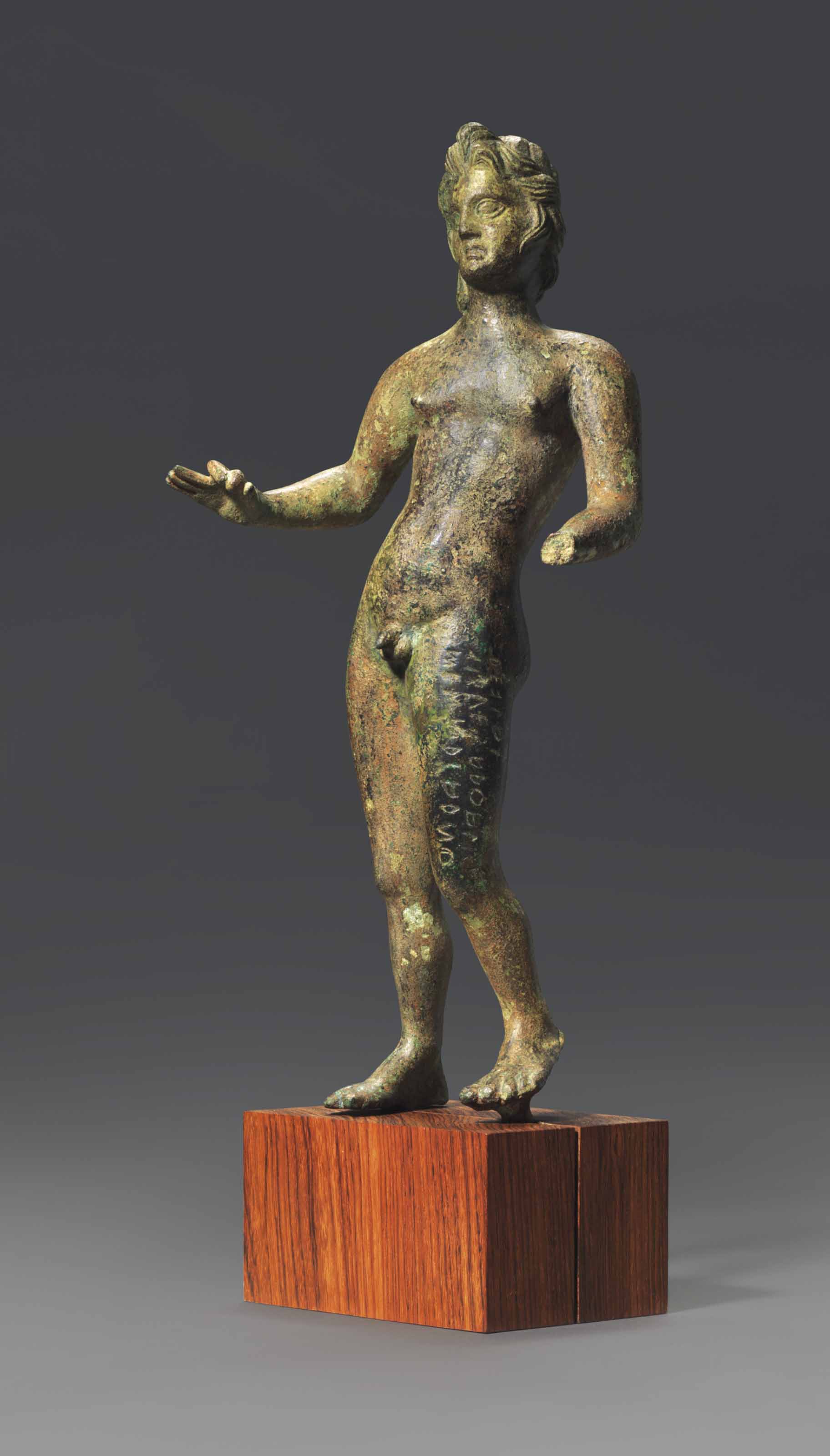 AN ETRUSCAN BRONZE VOTIVE FIGURE WITH INSCRIPTION