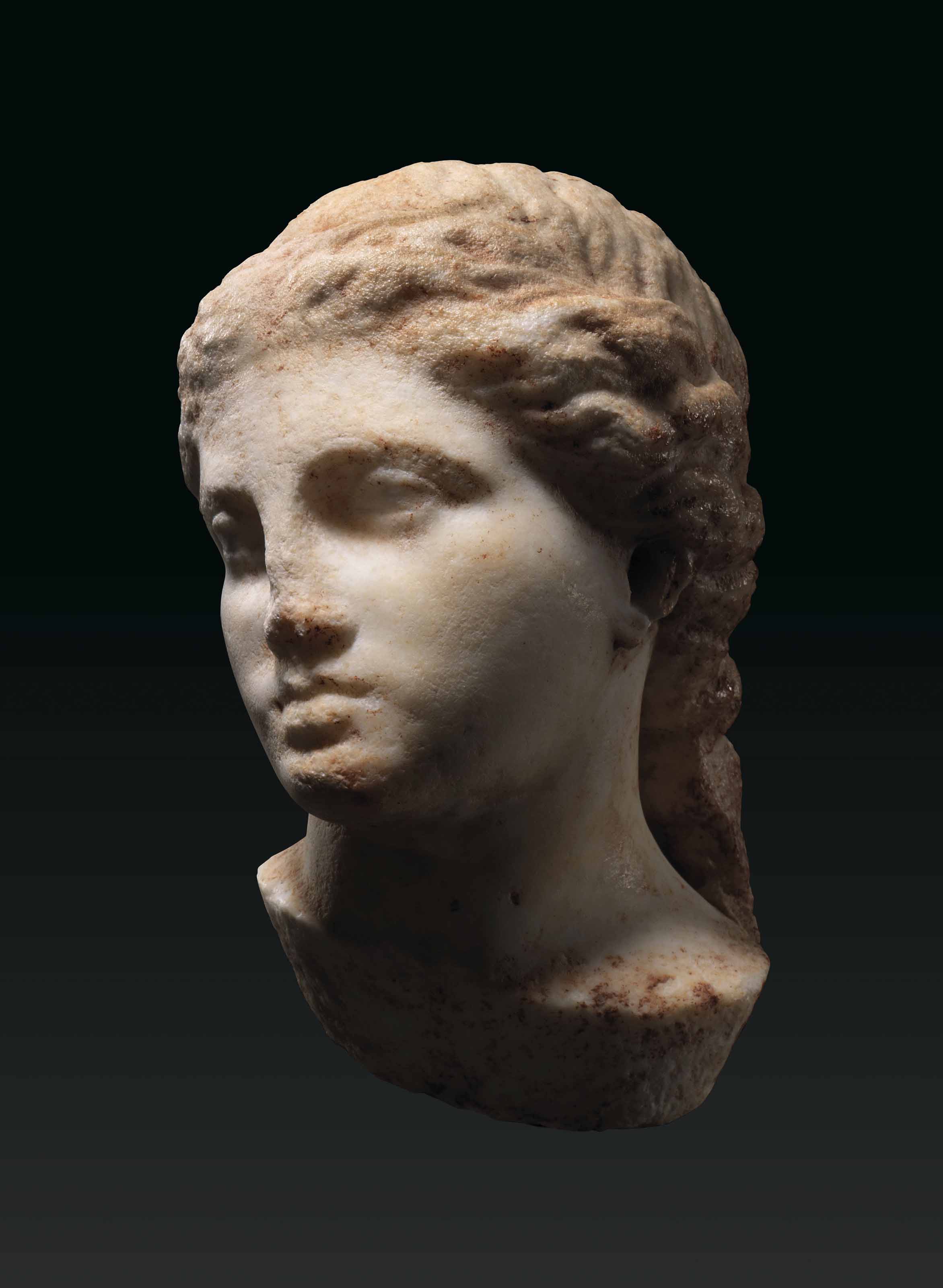 A GREEK MARBLE FEMALE HEAD , CLASSICAL PERIOD, CIRCA 4TH CENTURY B.C