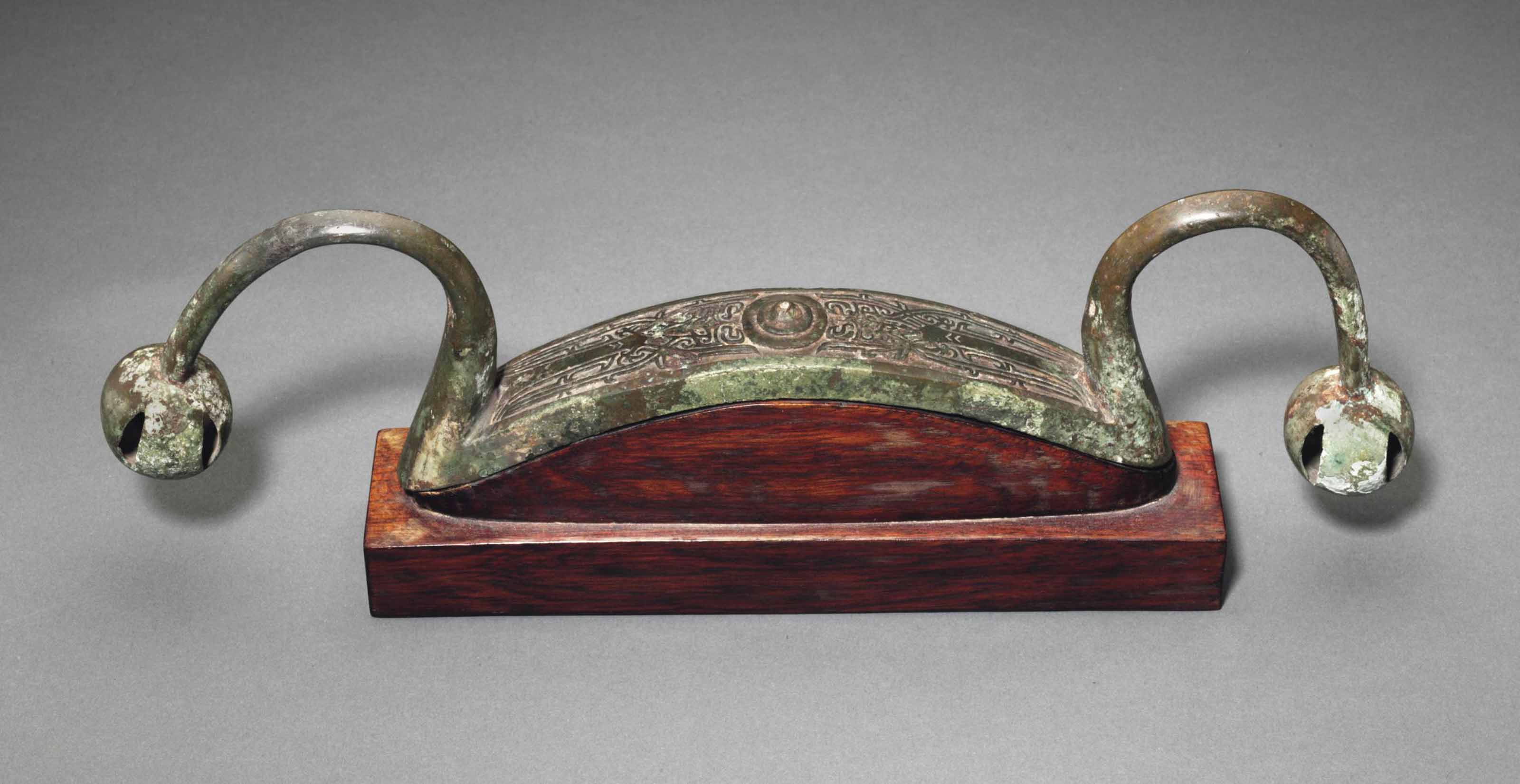 A BRONZE BOWSHAPED FITTING WITH JINGLES , LATE SHANG DYNASTY, 12TH