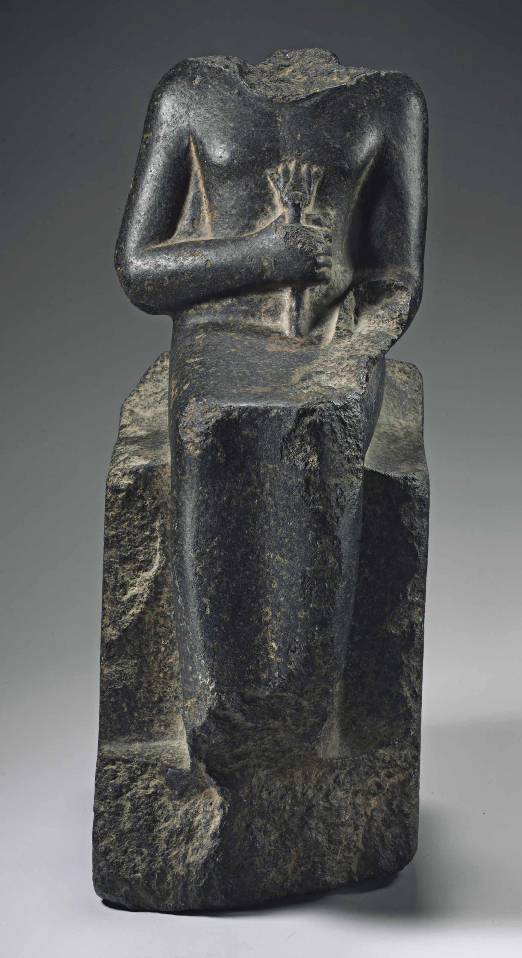 AN EGYPTIAN BLACK GRANITE SEATED SCULPTURE FOR NEITH, OVERSEER OF THE