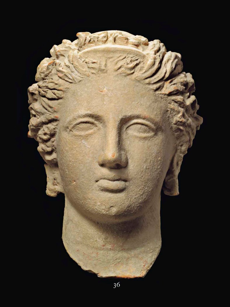 A GREEK TERRACOTTA VOTIVE FEMALE HEAD, TARAS, HELLENISTIC PERIOD, CIRCA ...