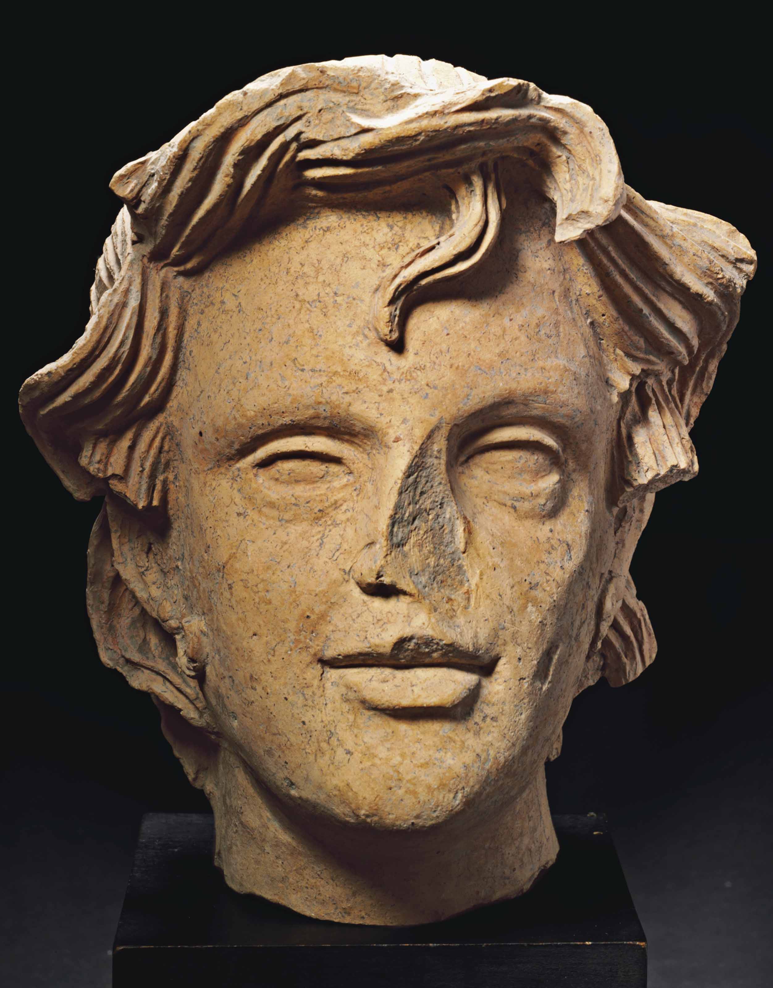 AN ETRUSCAN TERRACOTTA HEAD OF A GIRL , CIRCA LATE 4THEARLY 3RD
