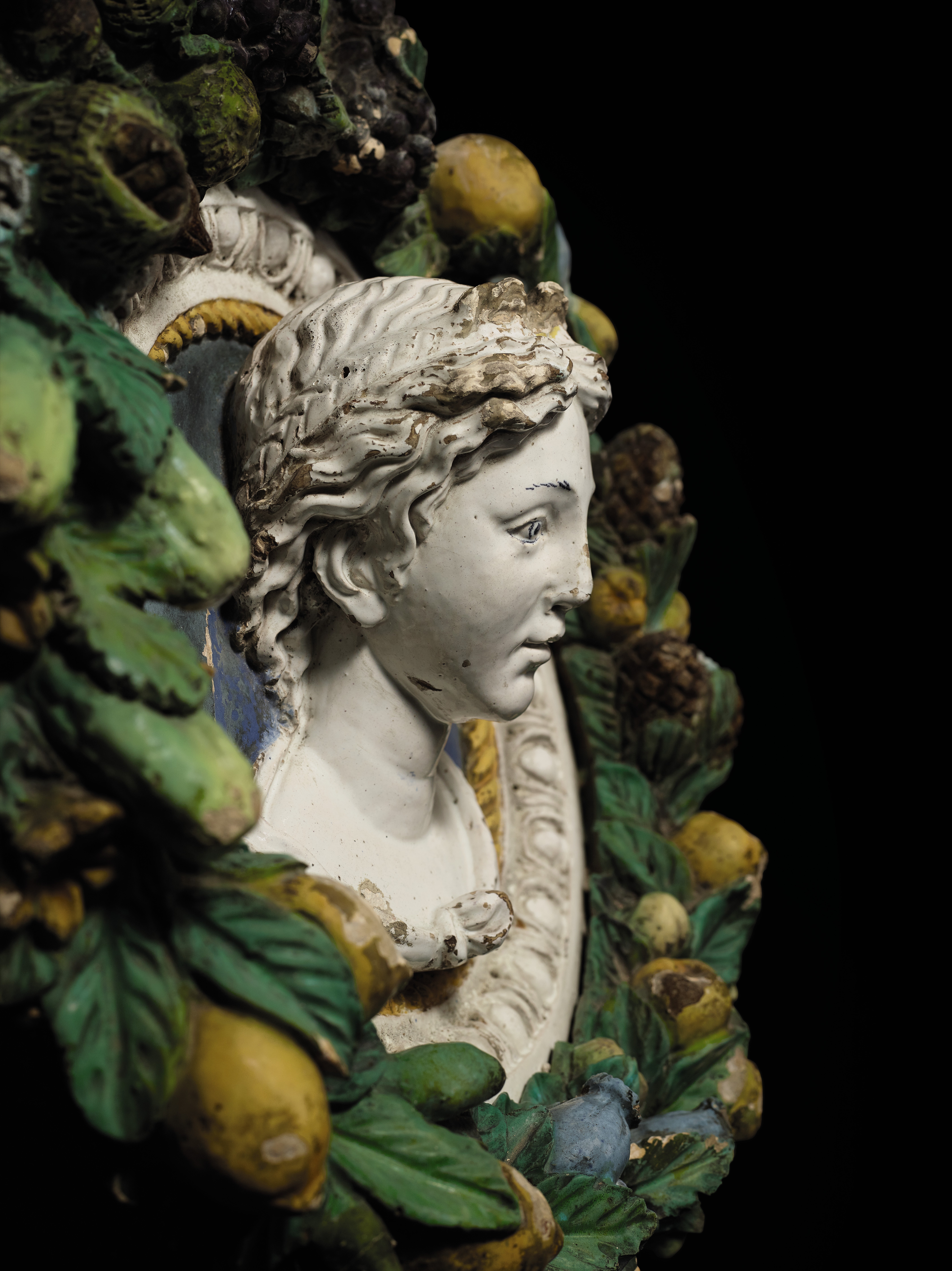 POLYCHROME-GLAZED TERRACOTTA BUST YOUTH FRAME FRUIT