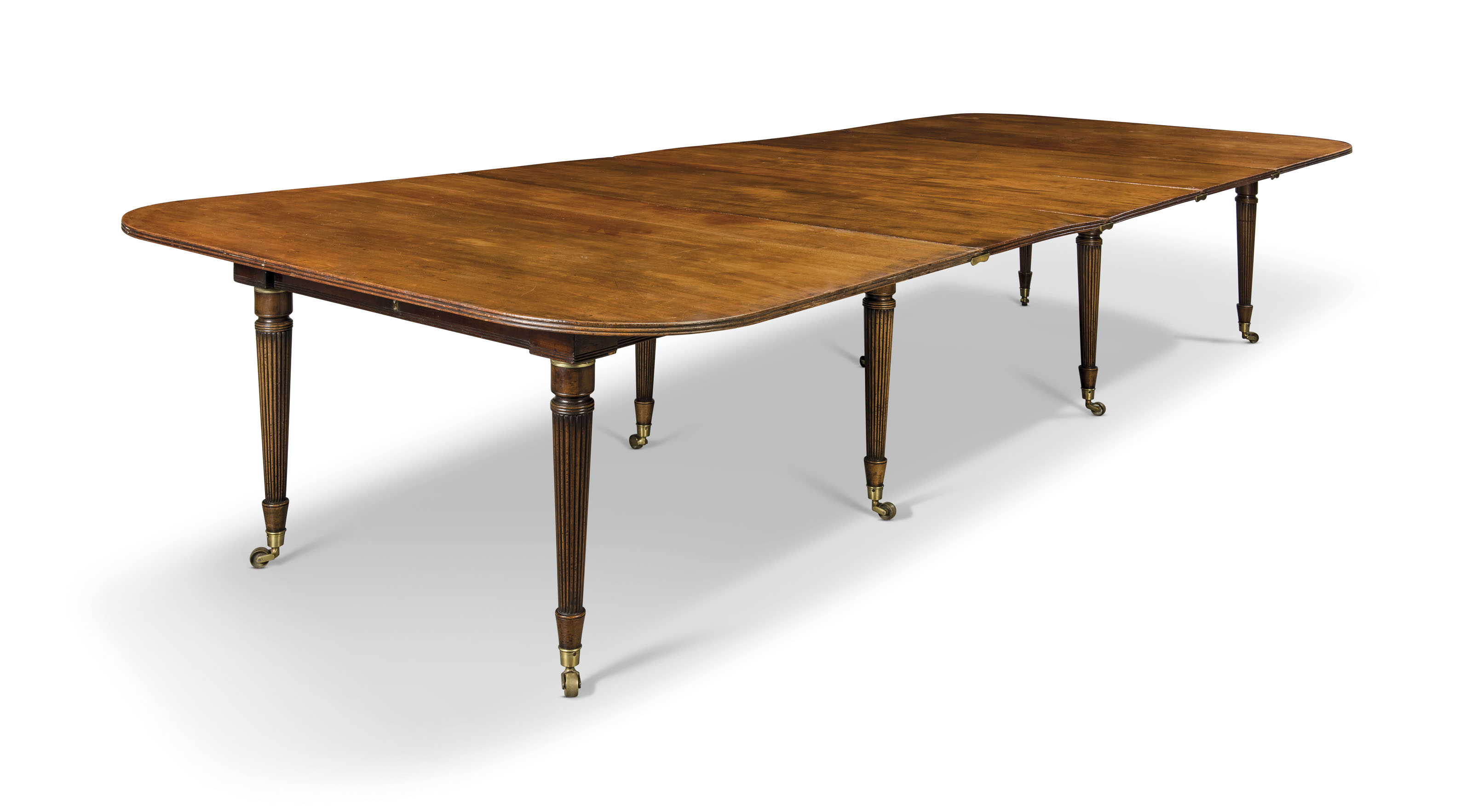 A MAHOGANY CAMPAIGN EXTENDING DININGTABLE , THE TOP REGENCY AND EARLY