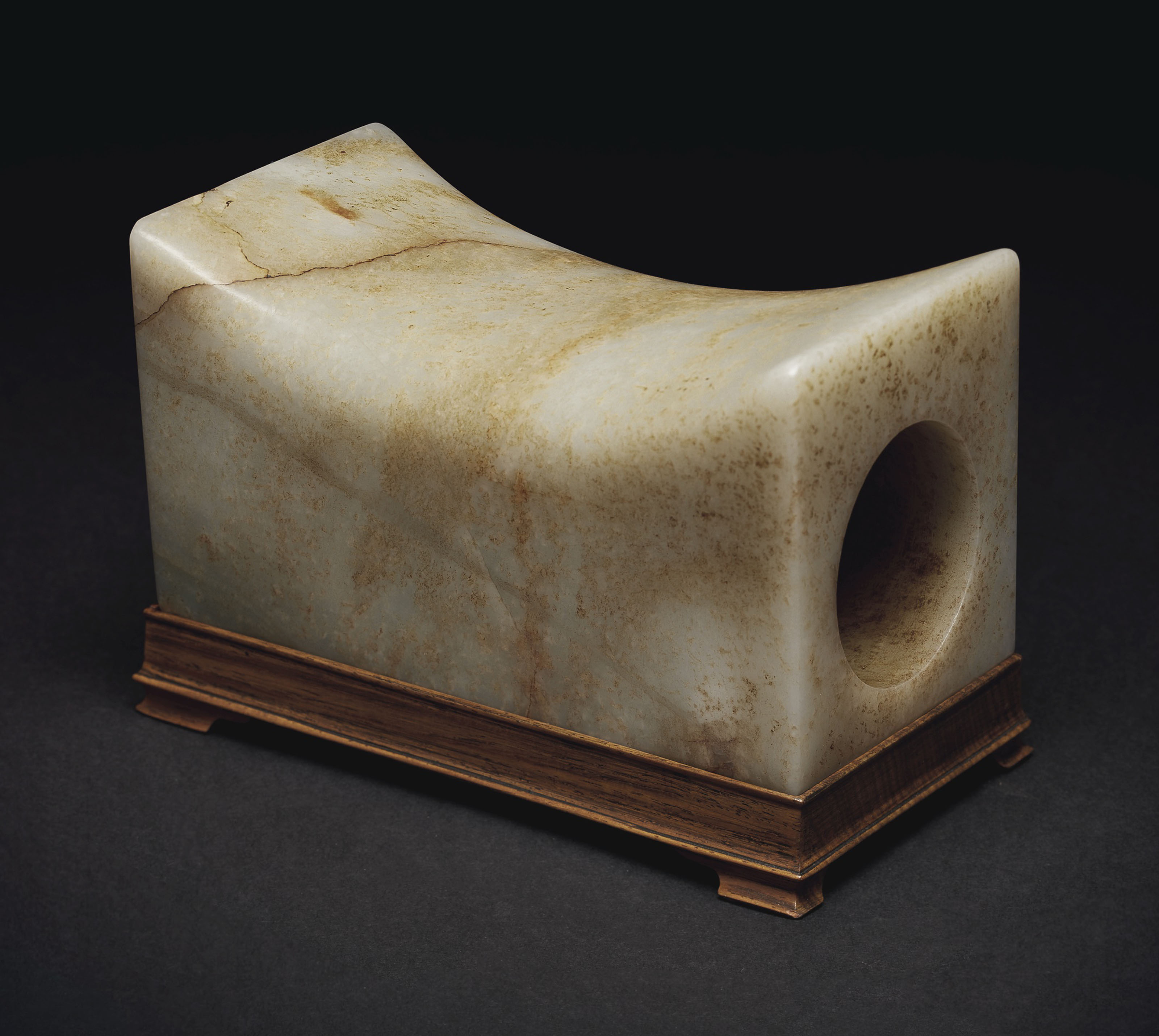 A mottled pale greenish-white and russet jade rectangular pillow, China, Ming dynasty (1368-1644) or later. 6⅞  in (17.4  cm) long. Sold for $60,000&nbsp;on 20 March 2019 at Christie&rsquo;s in New York