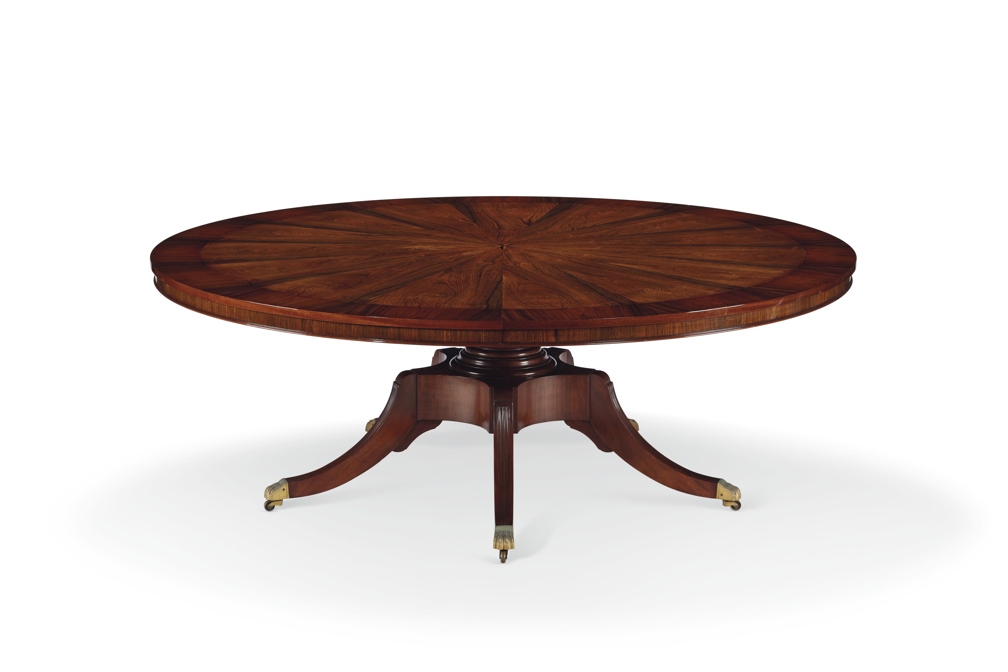 A MONKEY POD WOOD CIRCULAR EXTENSION DINING TABLE