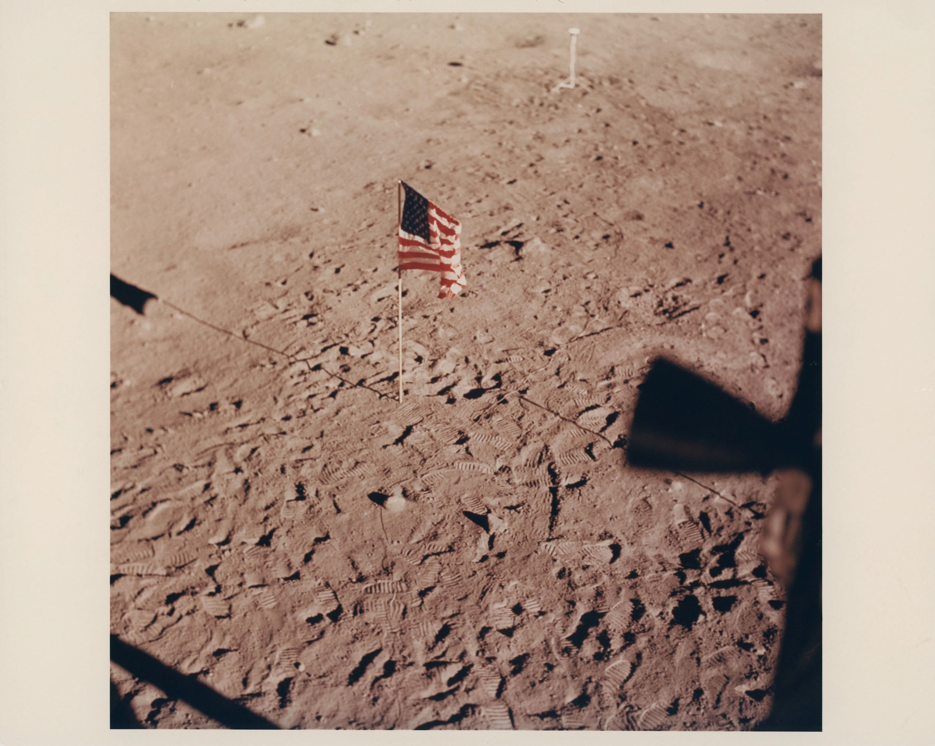 The US Flag and human footprints on the Moon; overexposed photograph of ...