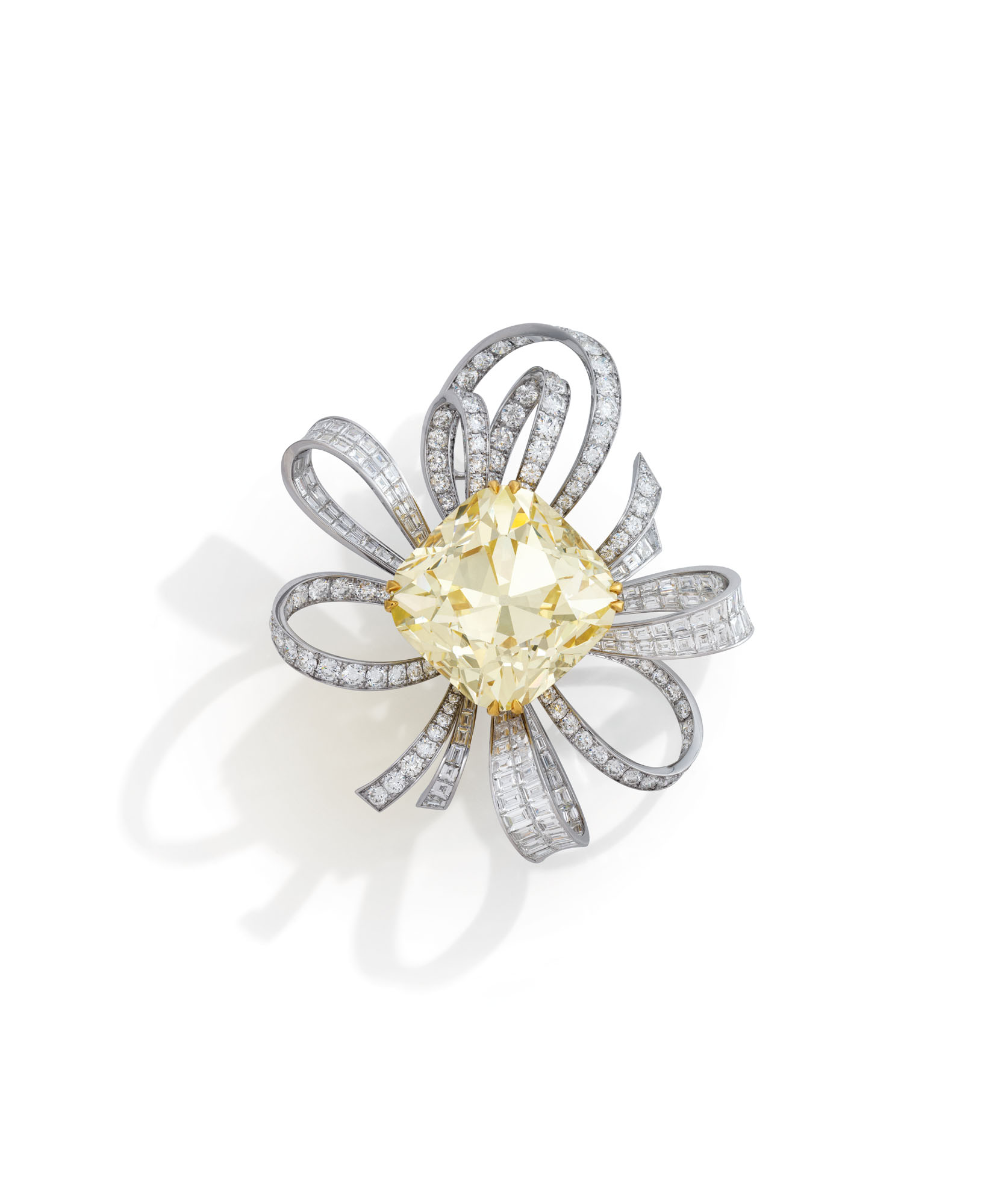 An exceptional coloured diamond and diamond brooch, by Graff. Fancy yellow round-cornered square brilliant-cut diamond of 107.46 carats, circular and baguette-cut diamonds. Sold for CHF 2,760,000 on 10 November 2020 at Christie&rsquo;s in Geneva