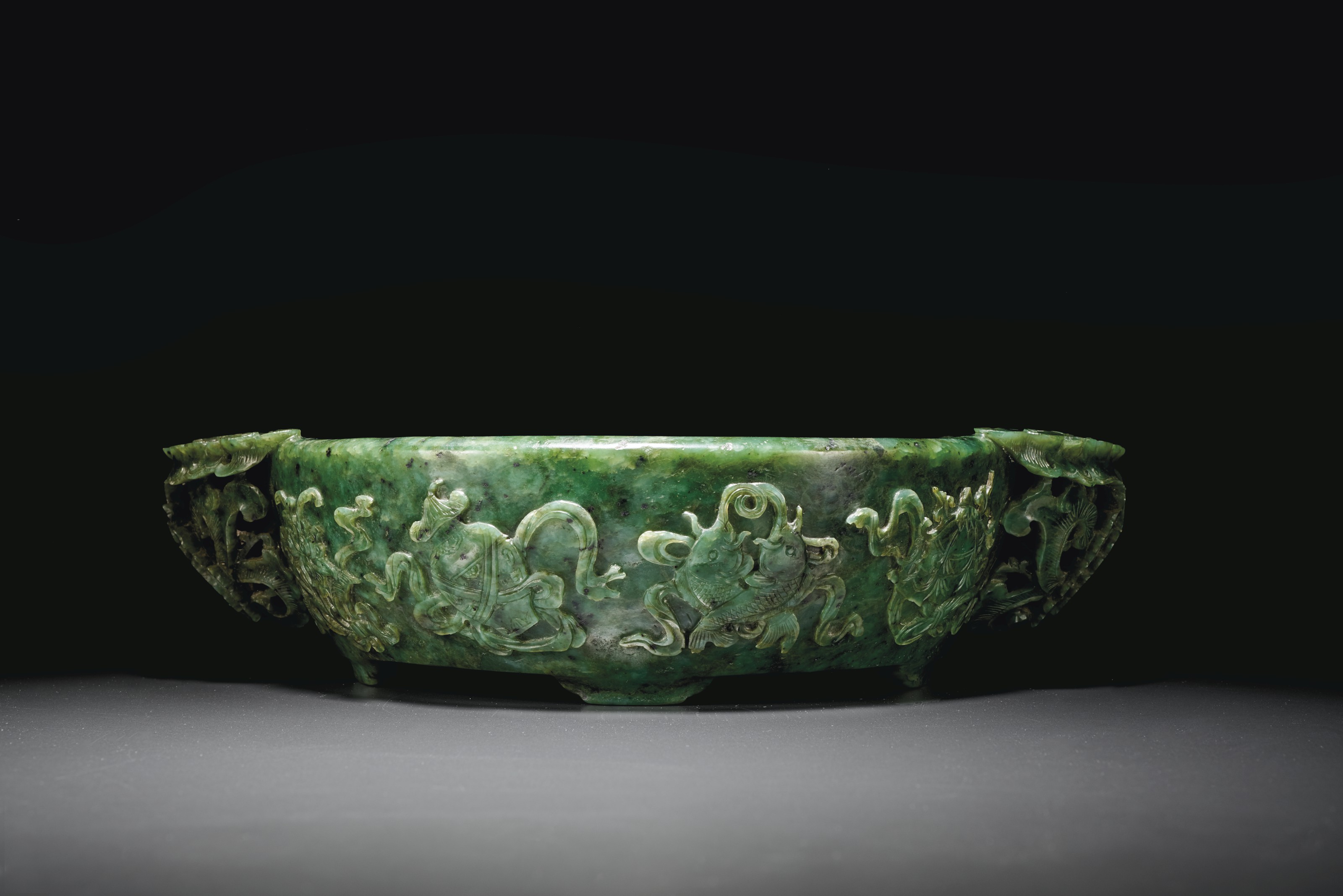 A RARE LARGE AND FINELY CARVED SPINACHGREEN JADE MARRIAGE BOWL