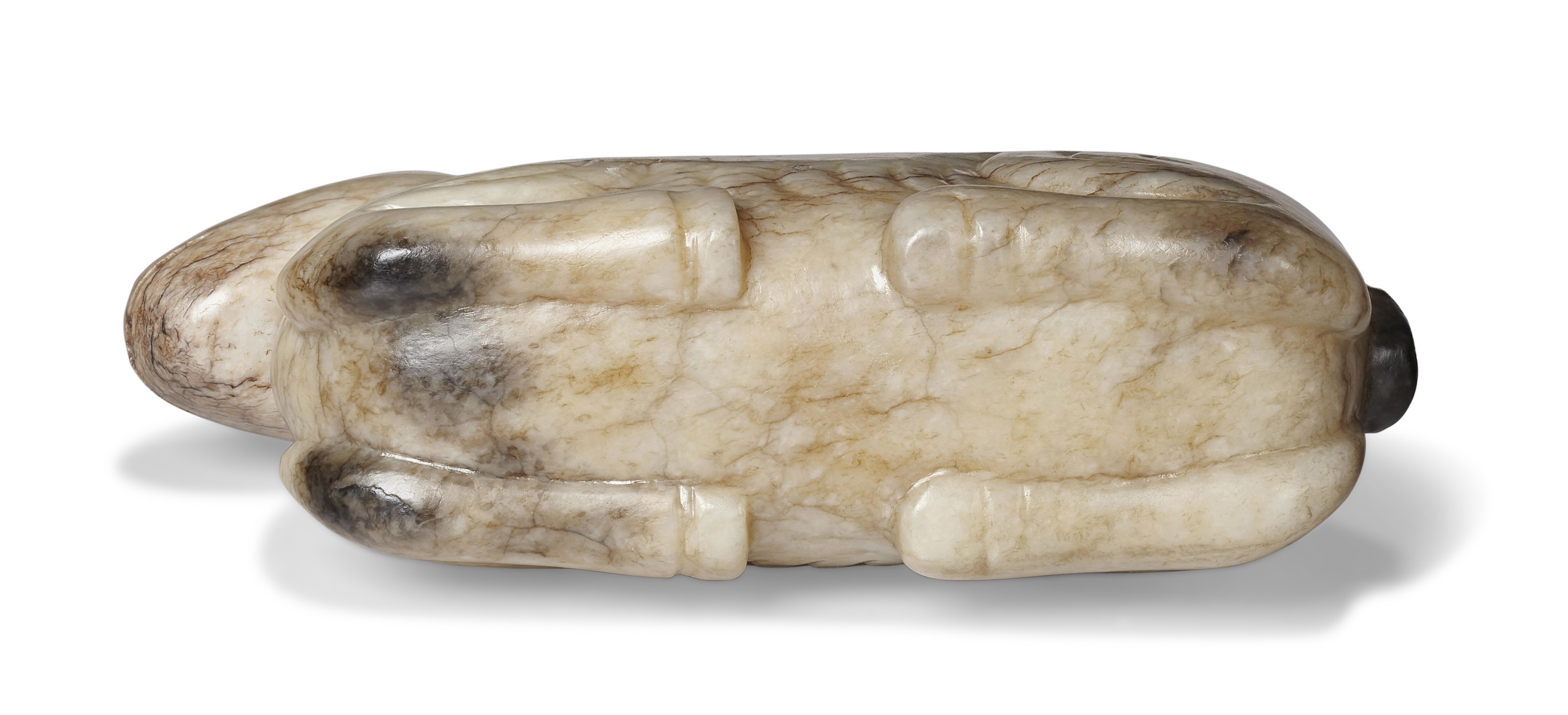 A 'CHICKEN BONE' JADE FIGURE OF A RECUMBENT CAMEL, CHINA, MING