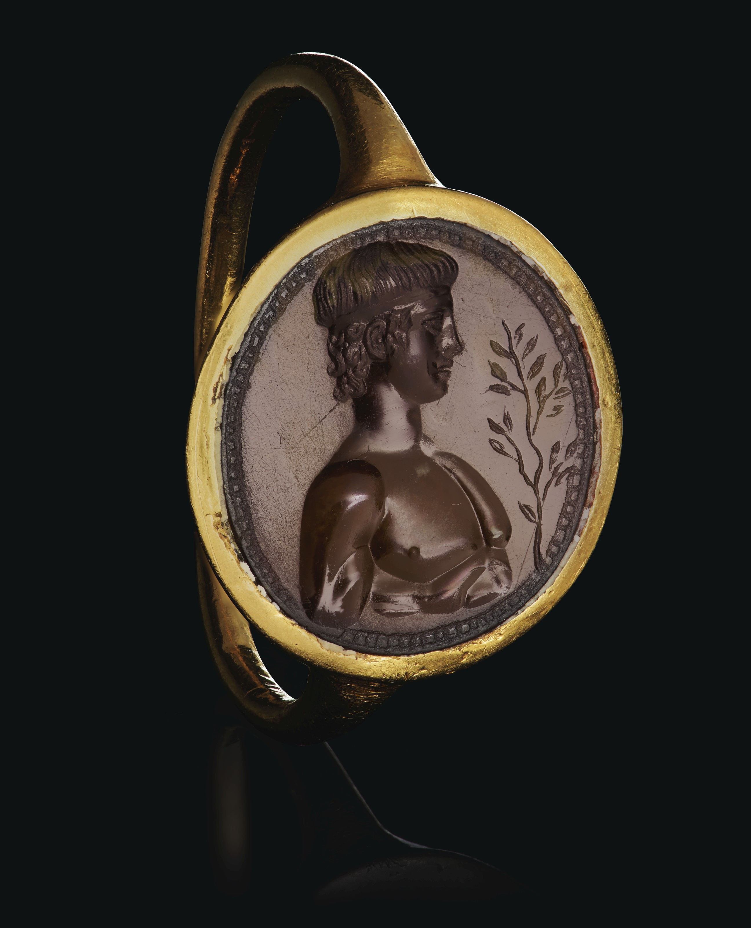 A ROMAN GOLD AND CARNELIAN FINGER RING WITH APOLLO, CIRCA 1ST