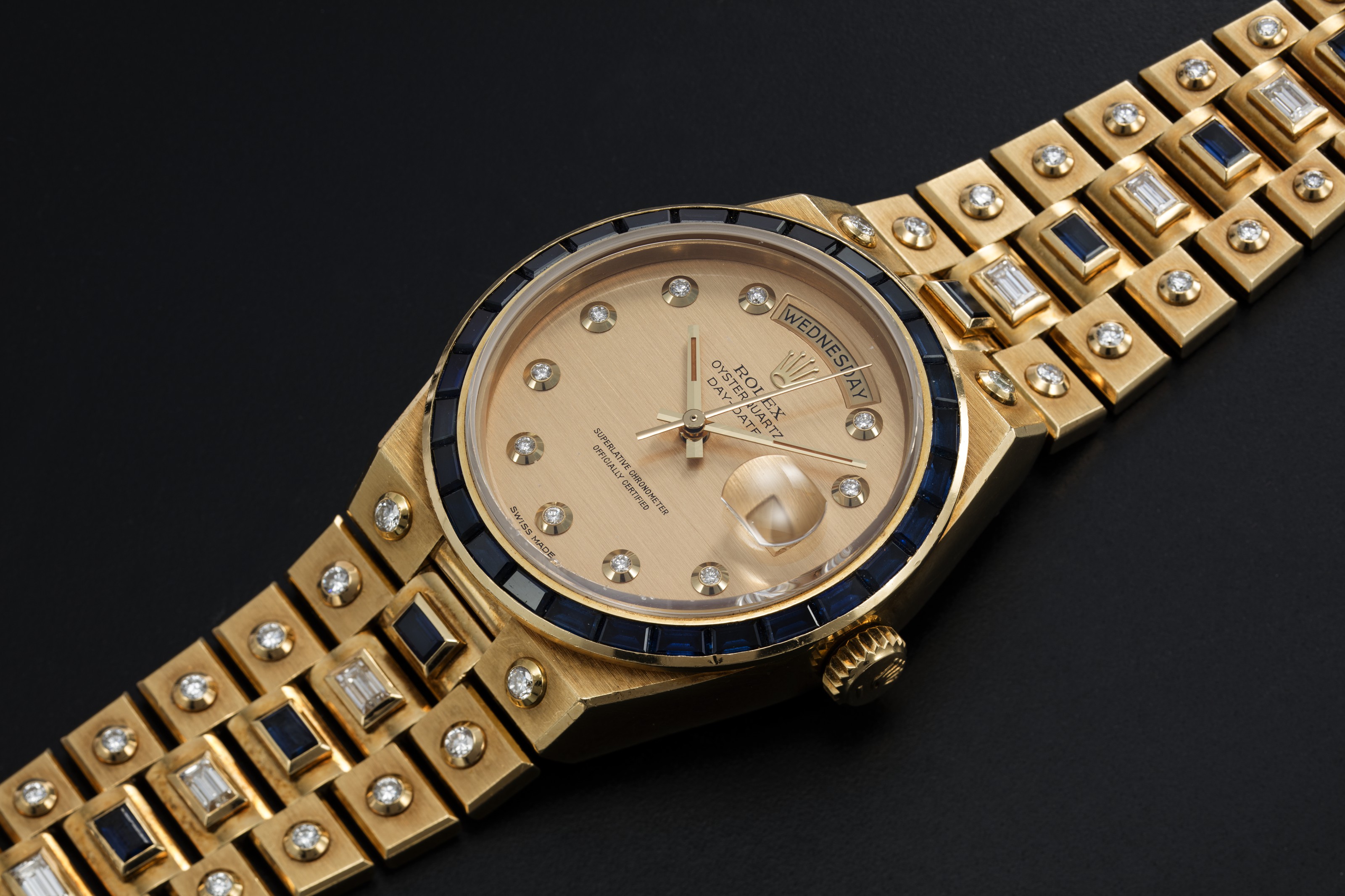 ROLEX MECCANO REF. 19168 A GOLD DAY DATE OYSTERQUARTZ SET WITH DIAMONDS AND SAPPHIRES CASE NUMBER 8 480 105 Christie s
