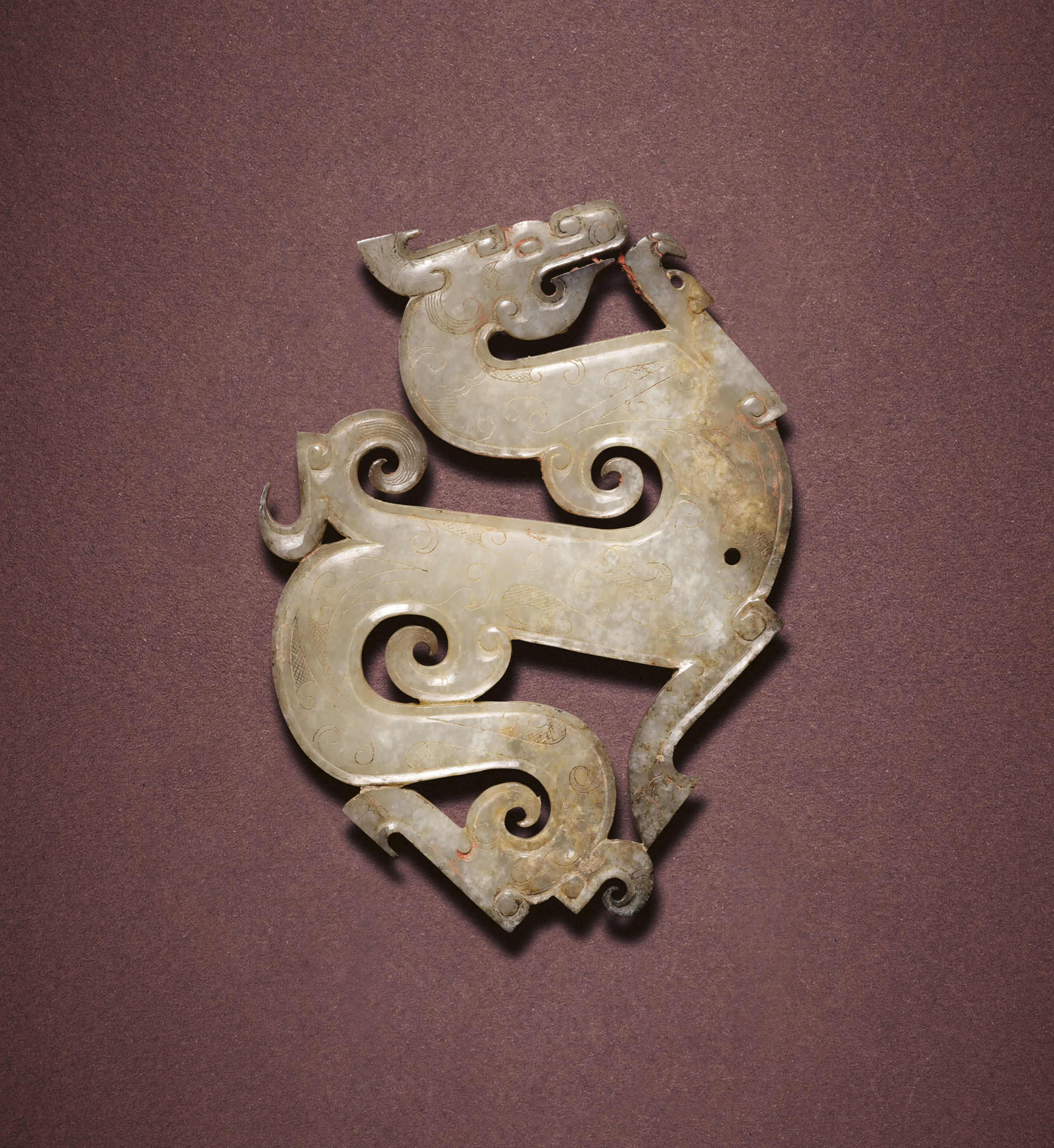 A very rare and finely carved jade dragon-form pendant, Late Warring States period, c. 300-221 BC. 9.1 cm (3⅝&nbsp;in) long, box. Sold for HK$15,250,000 on 3 December 2021 at Christie&rsquo;s in Hong Kong