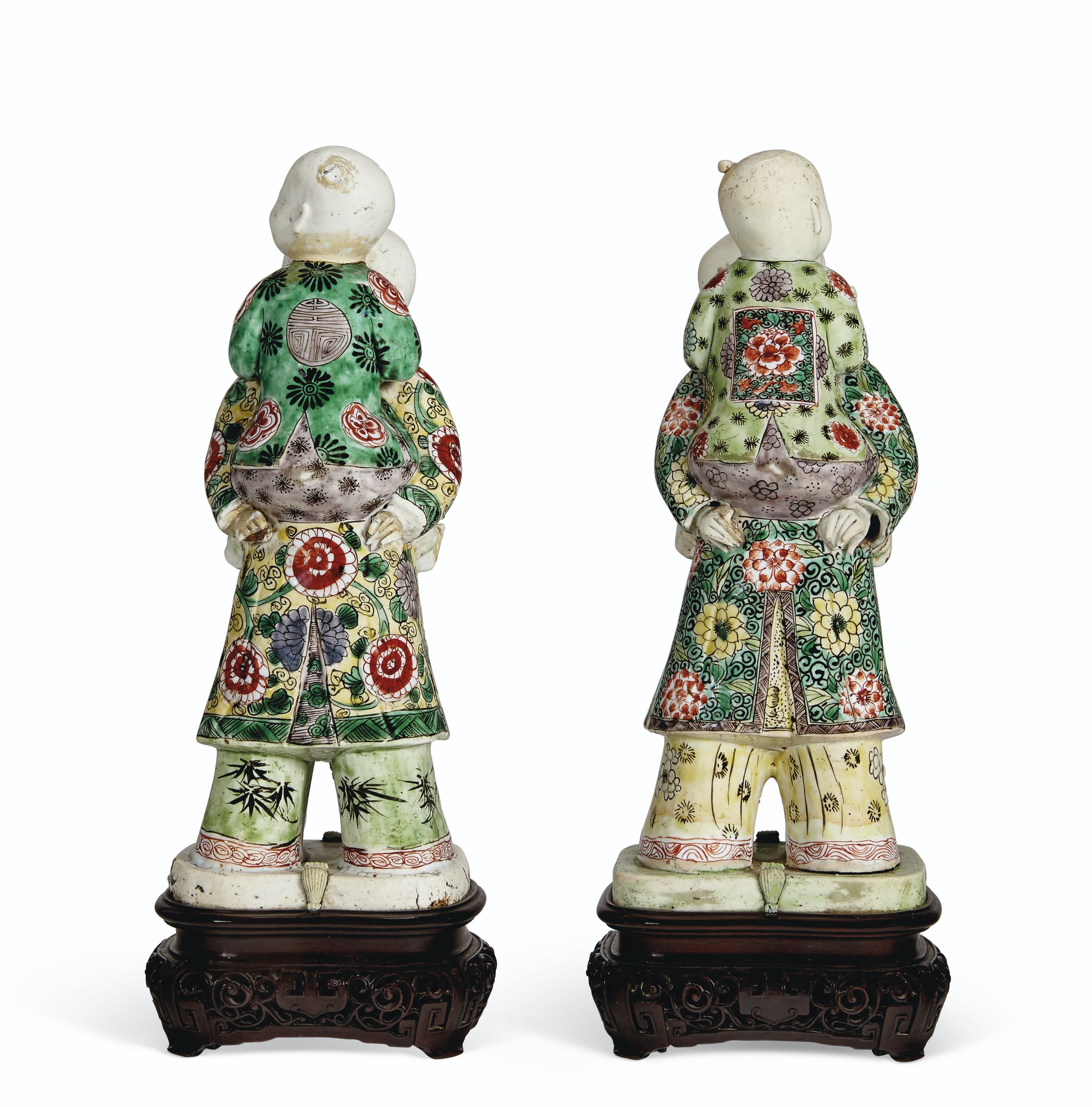 A PAIR OF FAMILLE VERTE BISCUIT-GLAZED PIGGYBACK BOYS, KANGXI