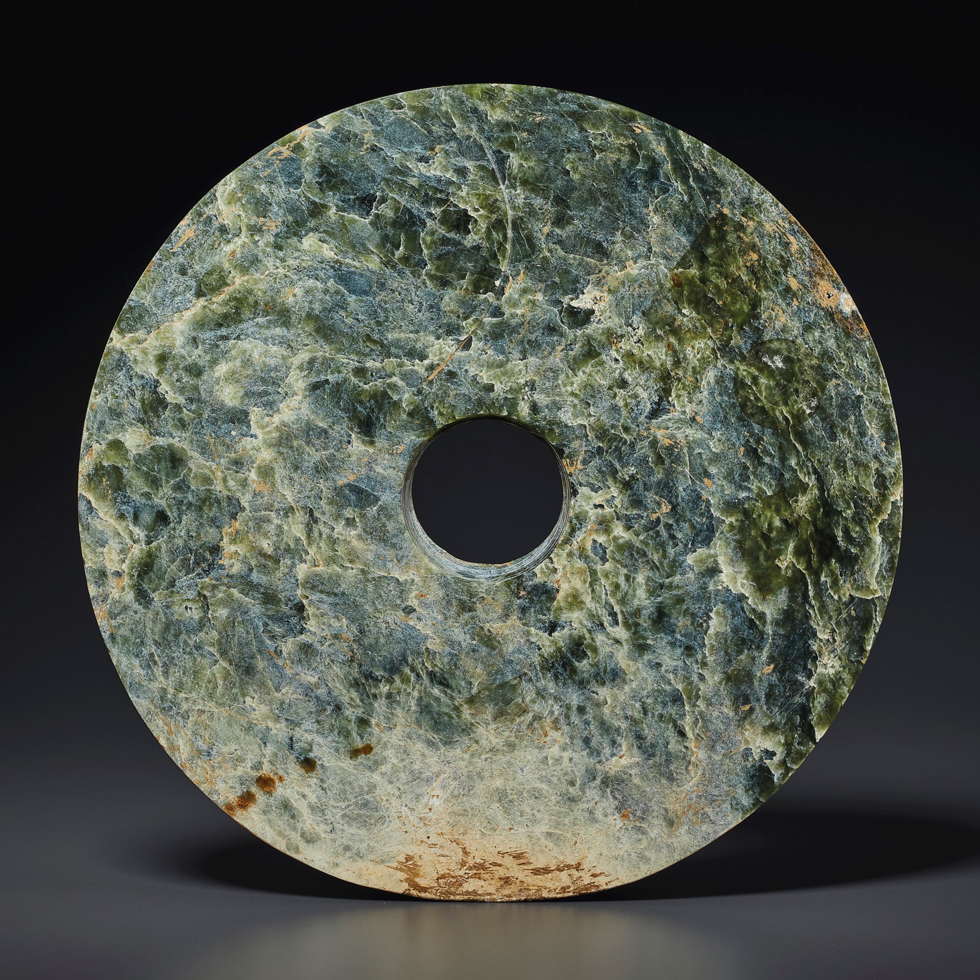 A LARGE MOTTLED GREEN JADE BI DISC
