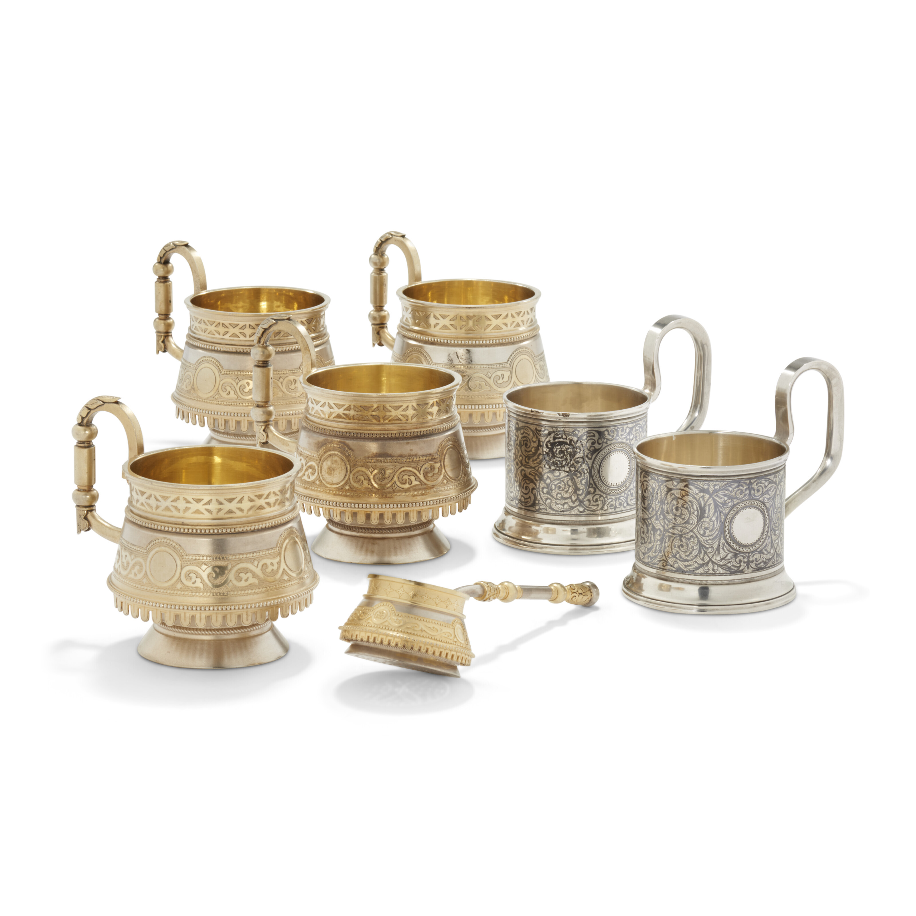 A GROUP OF SIX PARCELGILT SILVER GLASS HOLDERS AND A TEA STRAINER