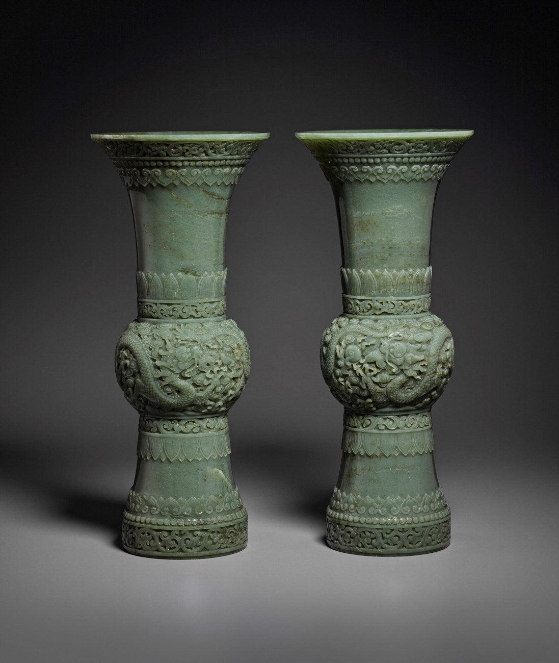 A RARE AND SUPERB PAIR OF FINELY CARVED GREEN JADE GUFORM VASES
