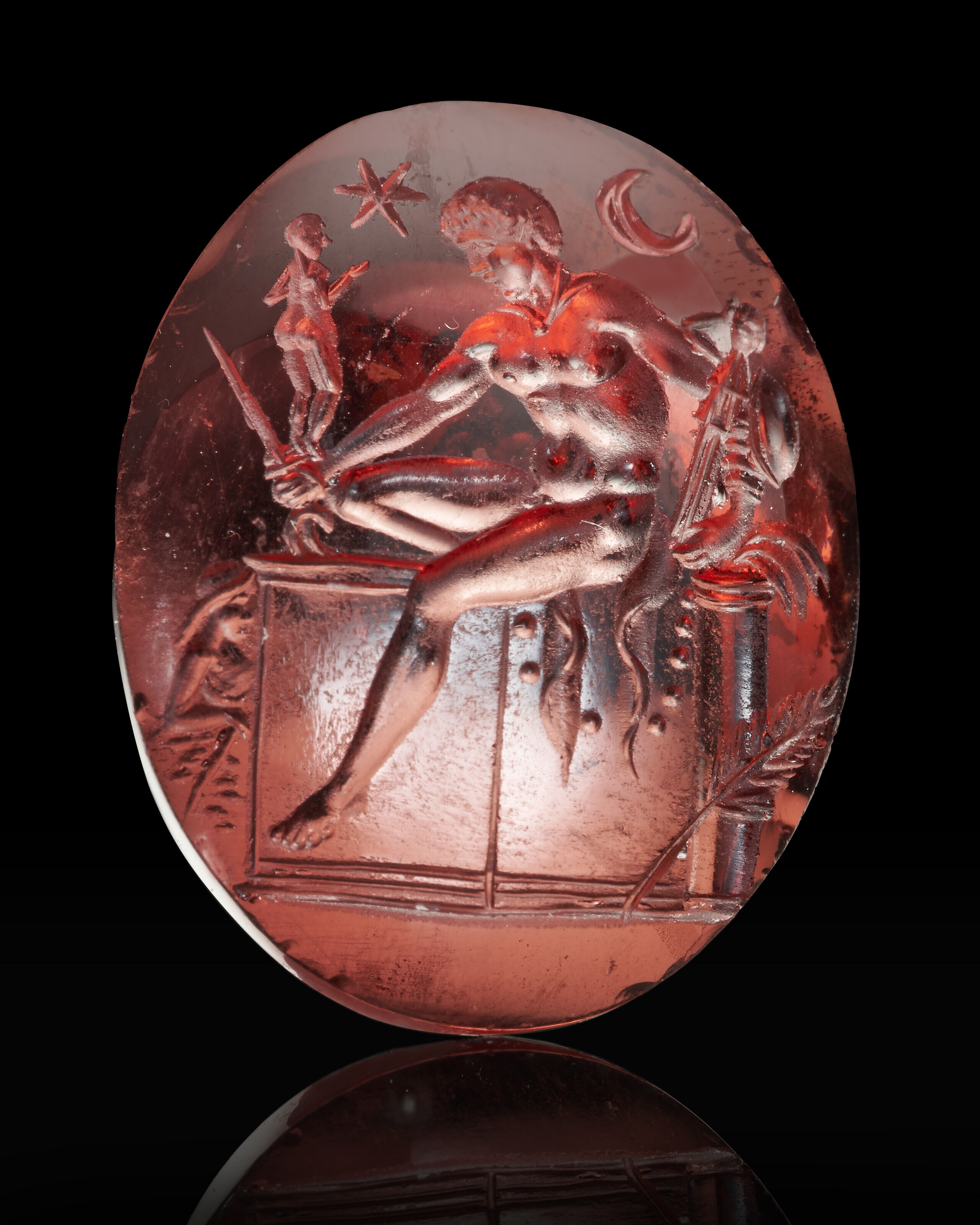 A Roman garnet ringstone with Diomedes, Imperial period, c. late 1st century BC-1st century AD. ¾  in (1.9  cm) long. Estimate: $10,000-15,000. Offered in Masterpieces in Miniature: Ancient Engraved Gems formerly in the G. Sangiorgi Collection Part III on 1-14 April 2022 at Christie’s Online