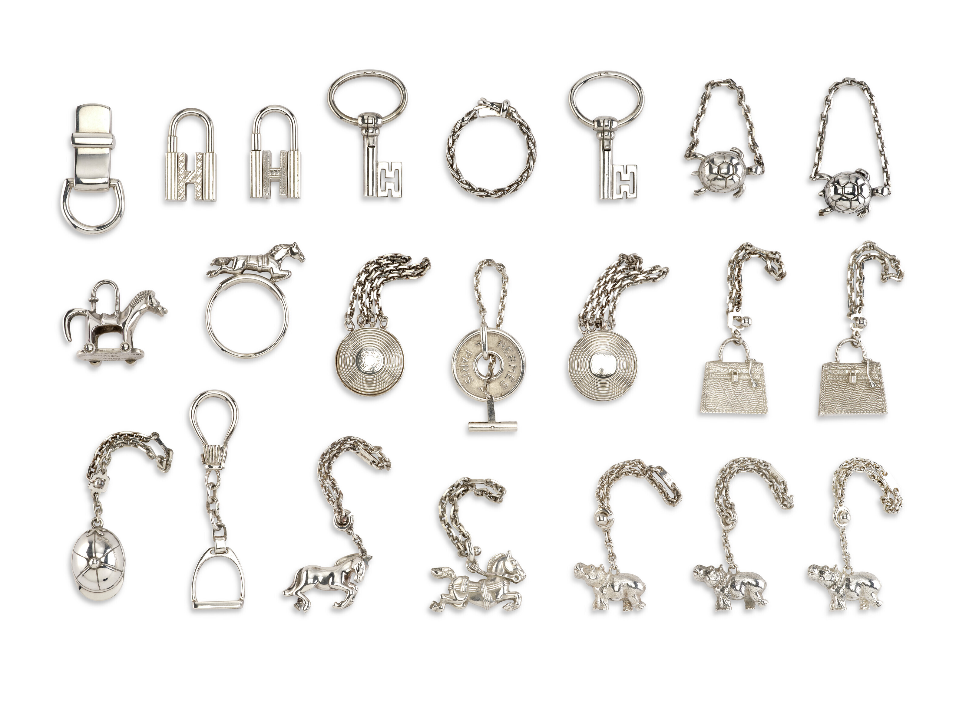 A GROUP OF TWENTYTWO SILVER CADENAS, KEY CHAINS & CHARMS, HERMÈS