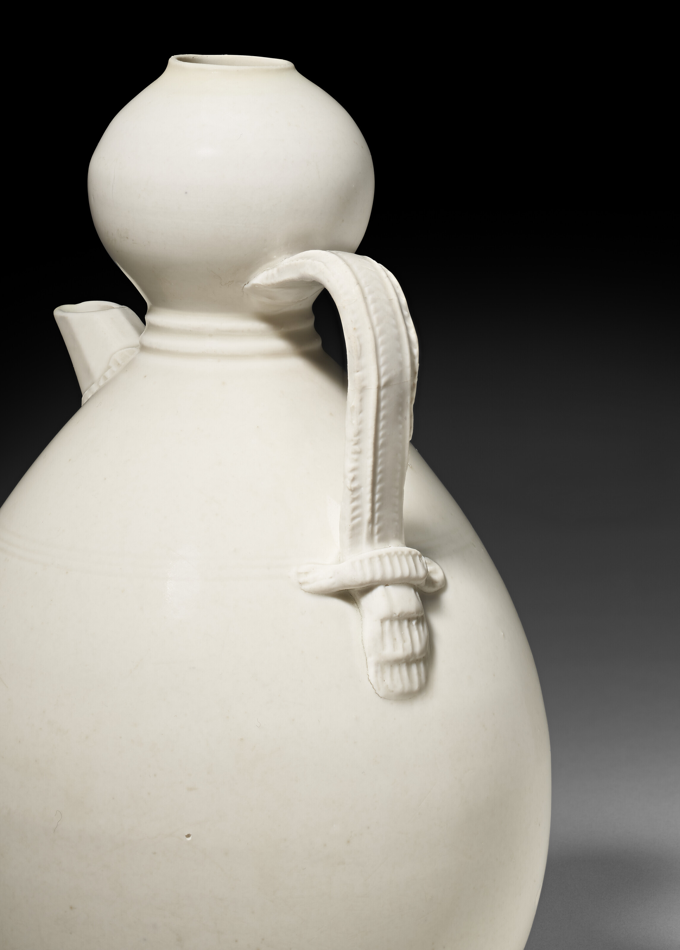 A RARE GLAZED WHITE PORCELAIN GOURD-FORM EWER, FIVE DYNASTIES