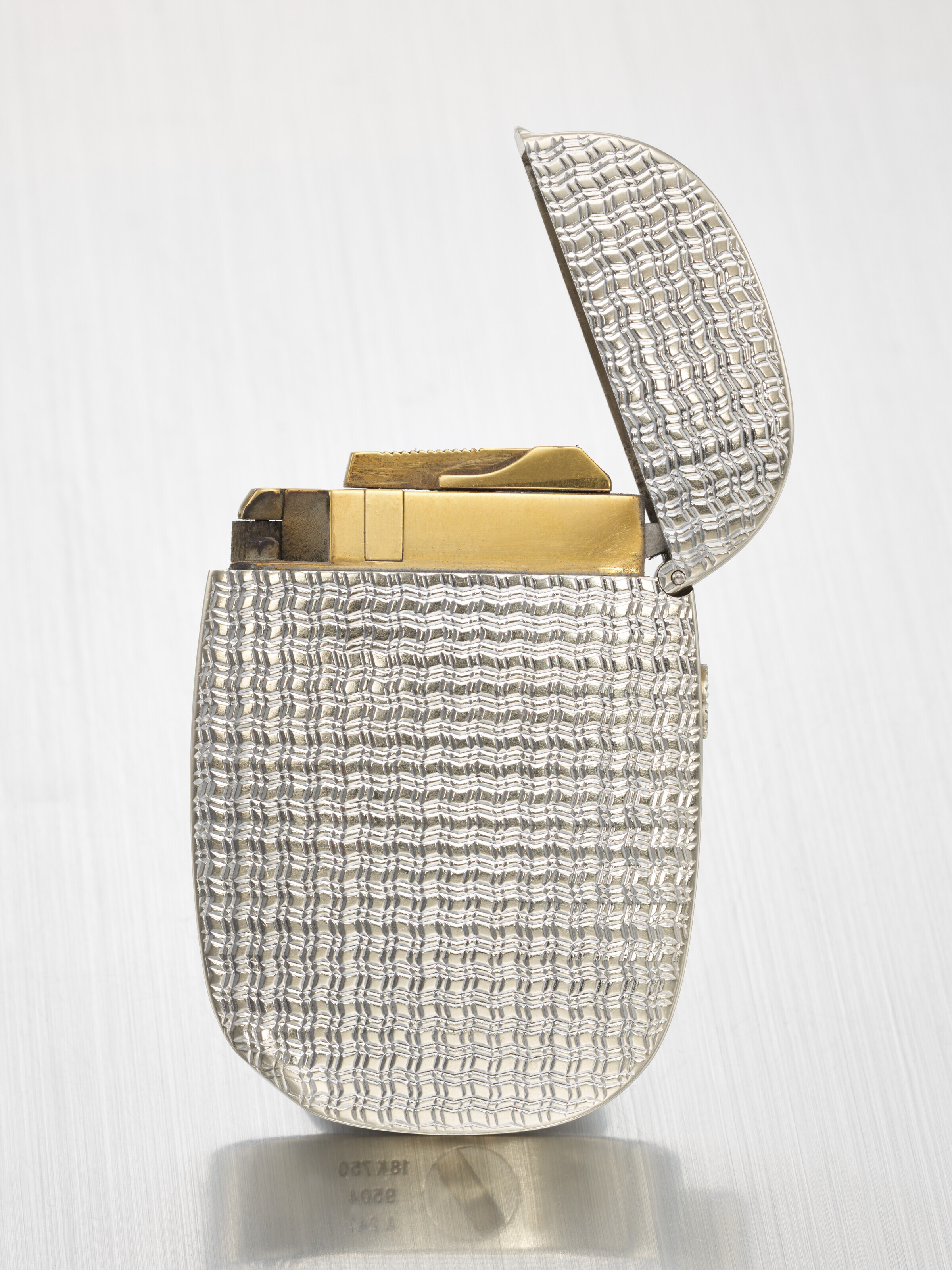 PATEK PHILIPPE. A RARE AND ATTRACTIVE 18K WHITE GOLD LIGHTER WITH OCEAN ENGRAVING DECORATION SIGNED PATEK PHILIPPE REF. 9504 CASE NO. A241 CIRCA 1980 Christie s