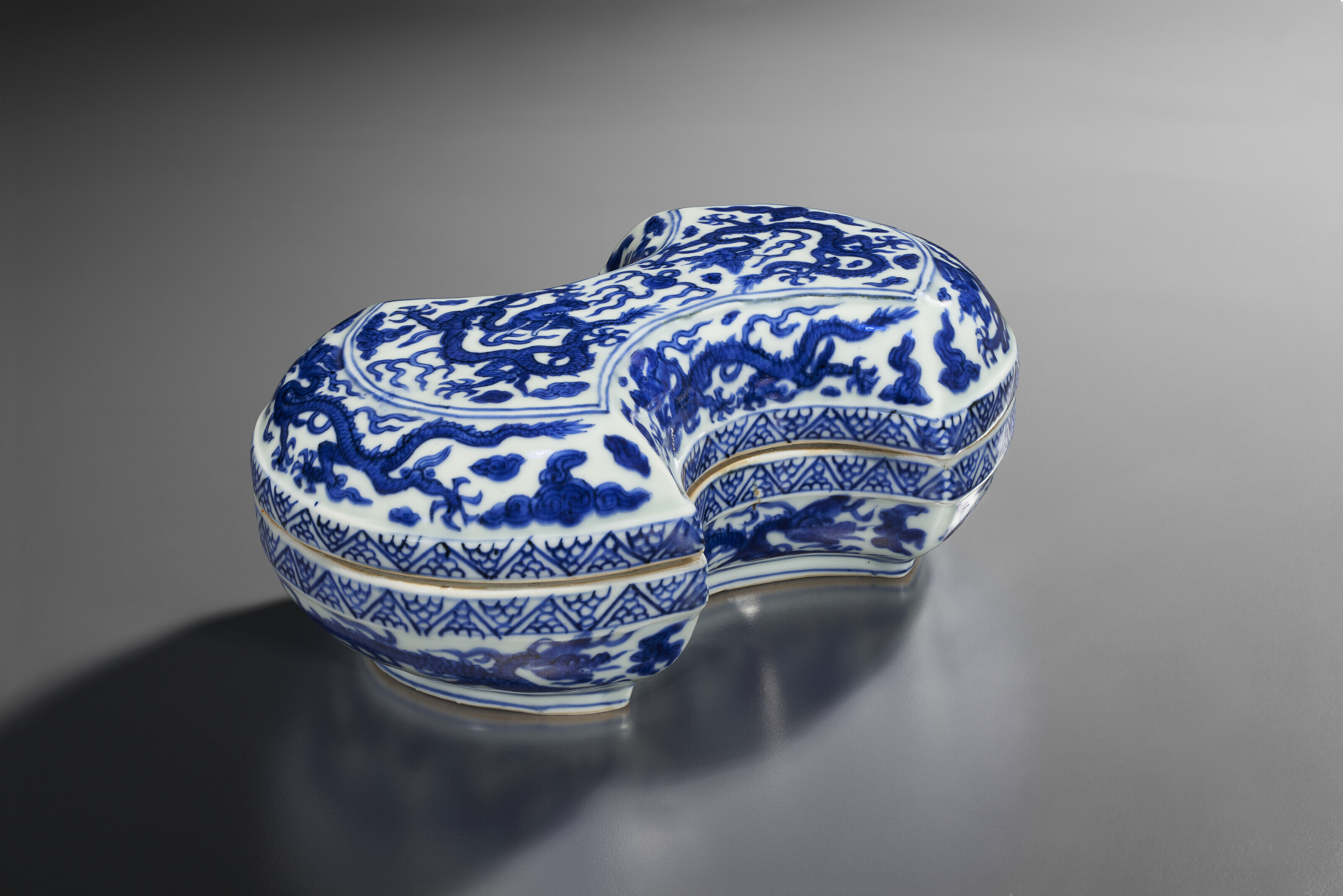 A RARE BLUE AND WHITE INGOT-SHAPED 'DRAGON' BOX AND COVER