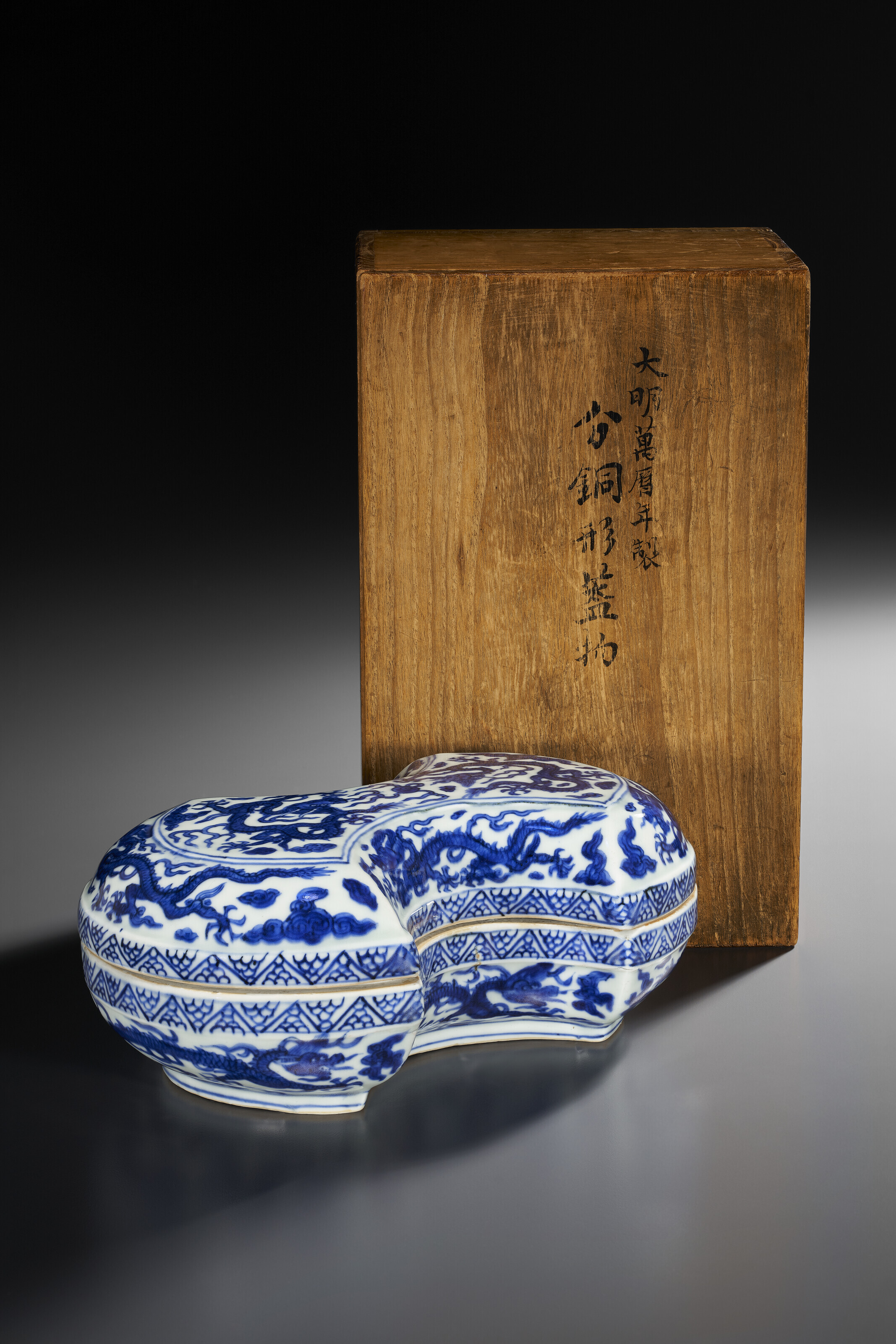 A RARE BLUE AND WHITE INGOT-SHAPED 'DRAGON' BOX AND COVER