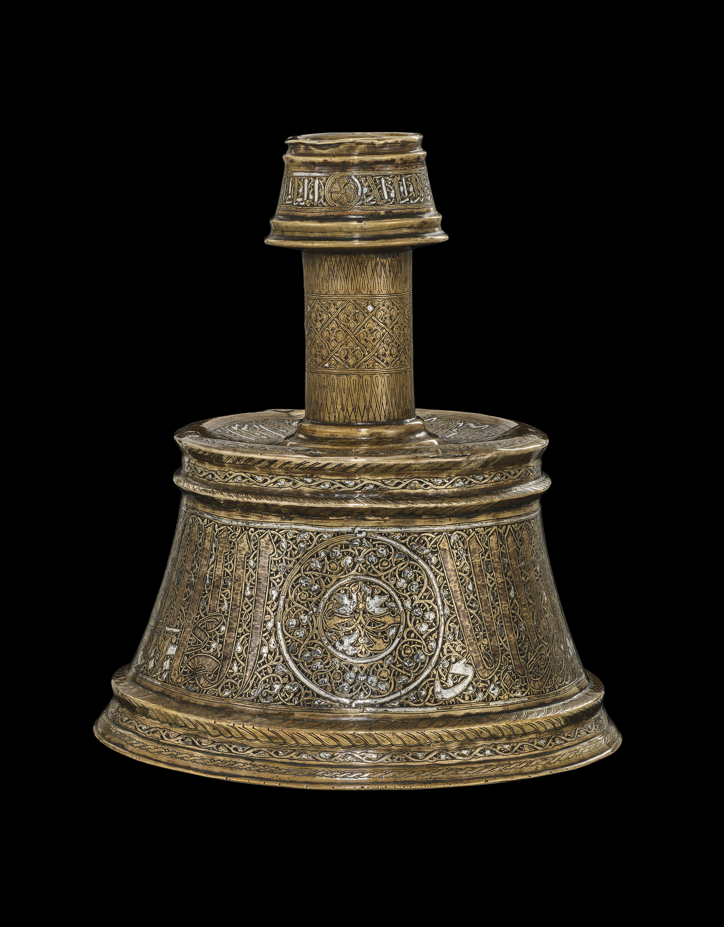 A large Mamluk silver-inlaid brass candlestick, Egypt or Syria, Period of Sultan al-Nasir al-Din Muhammad bin Qala'un (1293-1341), first half 14th century, offered in Art of the Islamic and Indian Worlds including Rugs and Carpets on 25 April 2024 at Christie's in London
