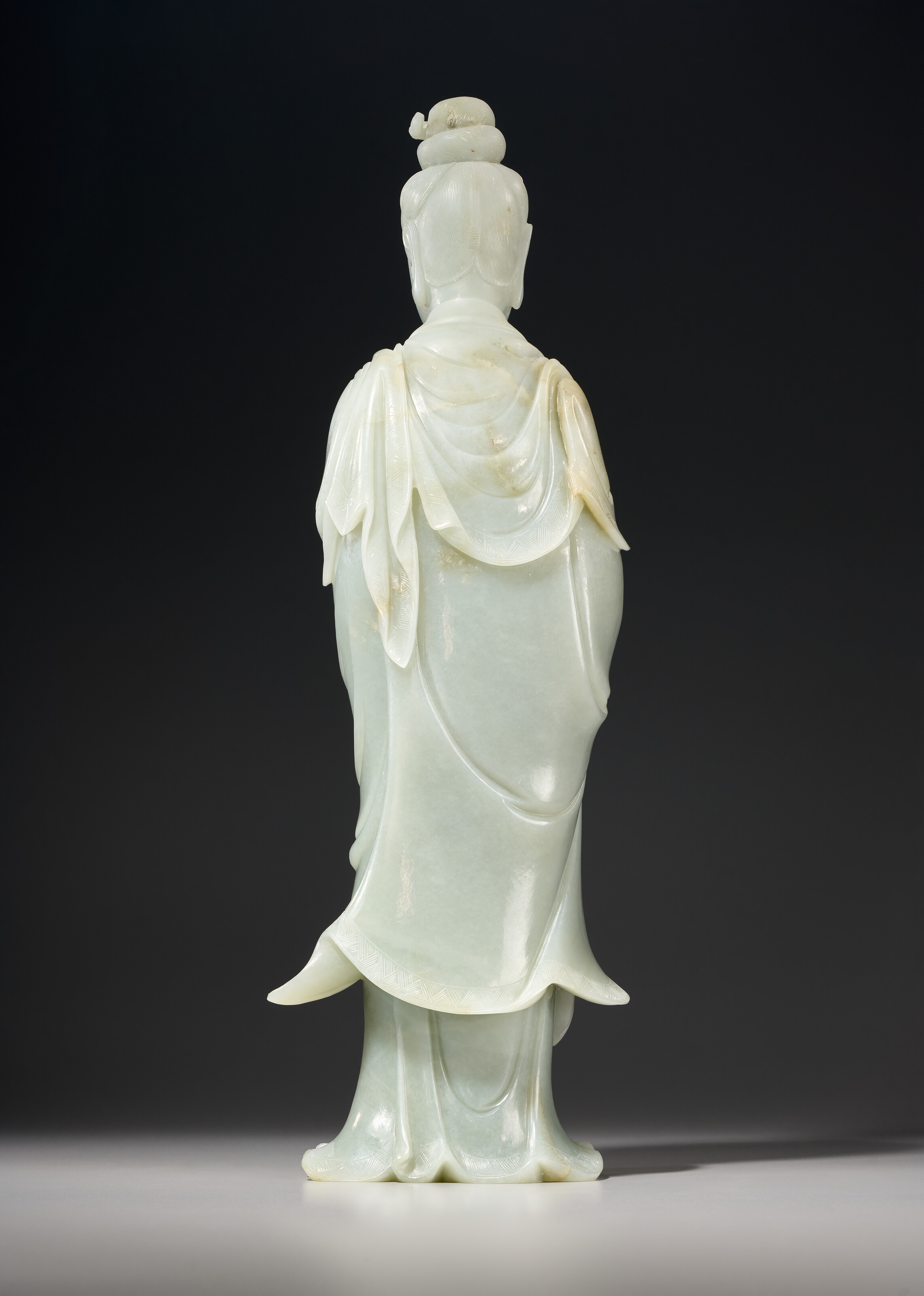 A LARGE GREENISH-WHITE JADE FIGURE OF GUANYIN, LATE QING DYNASTY