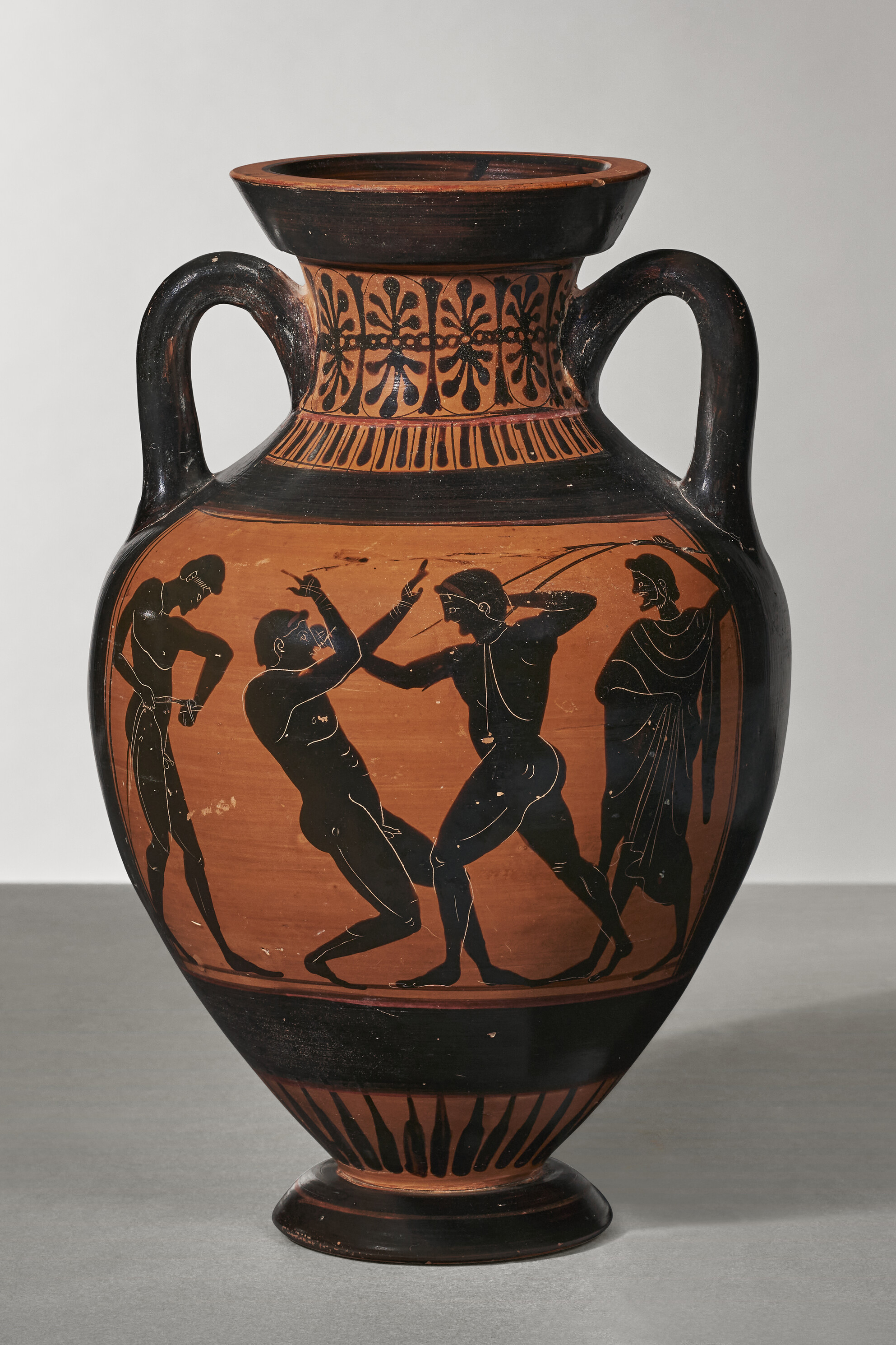 On one side of the amphora is Athena, between a pair of columns topped with cockerels; on the other is a boxing match, with a bearded judge on the right and a young man on the left, preparing to fight the victor