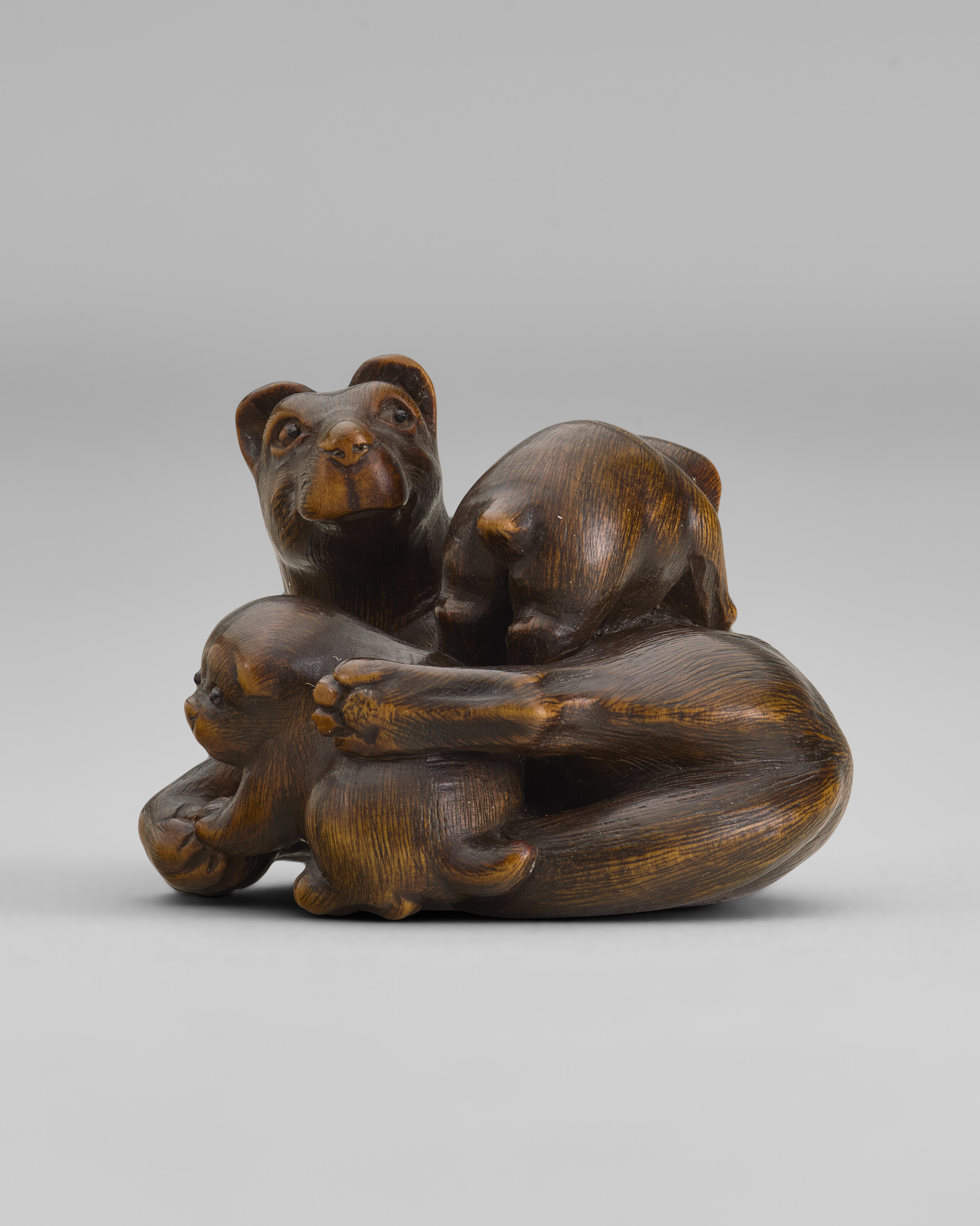A CARVED WOOD NETSUKE OF DOGS, EDO PERIOD (19TH CENTURY), SIGNED