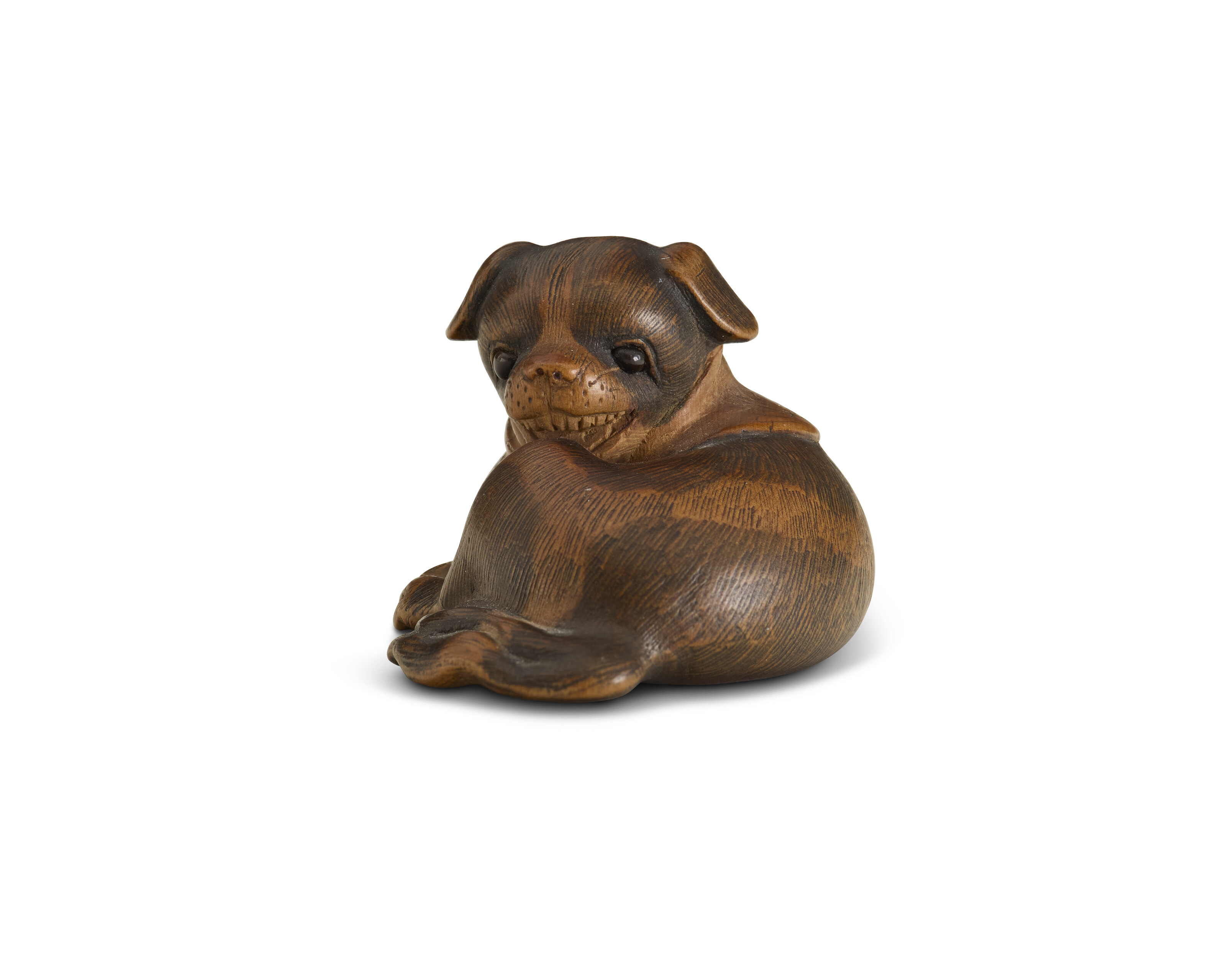 A CARVED WOOD NETSUKE OF A RECUMBENT DOG, JAPAN, EDO PERIOD (19TH