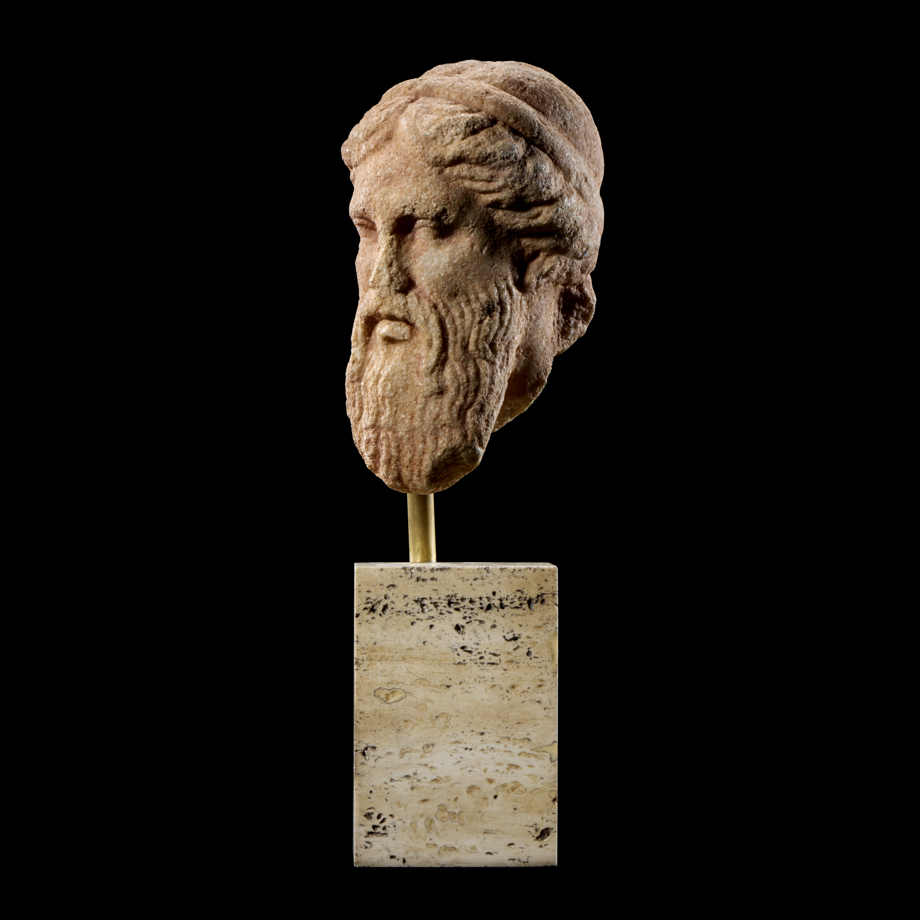 A Greek marble relief head of a bearded god, early Classical period, circa 5th century B.C., offered in Antiquities on 2 July 2025 at Christie's in London