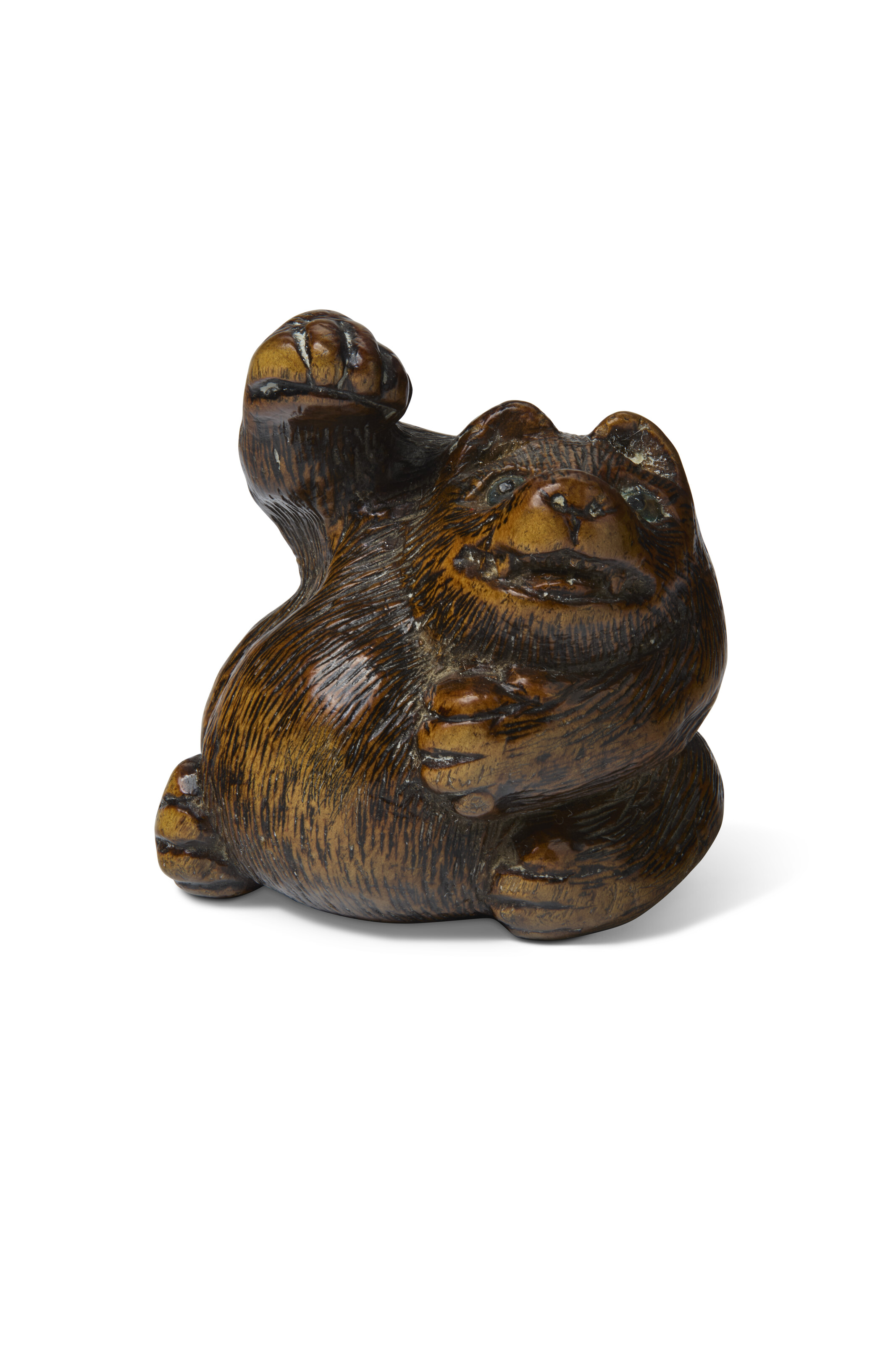 A CARVED WOOD SCULPTURE NETSUKE OF A BADGER WITH RAISED PAW, EDO