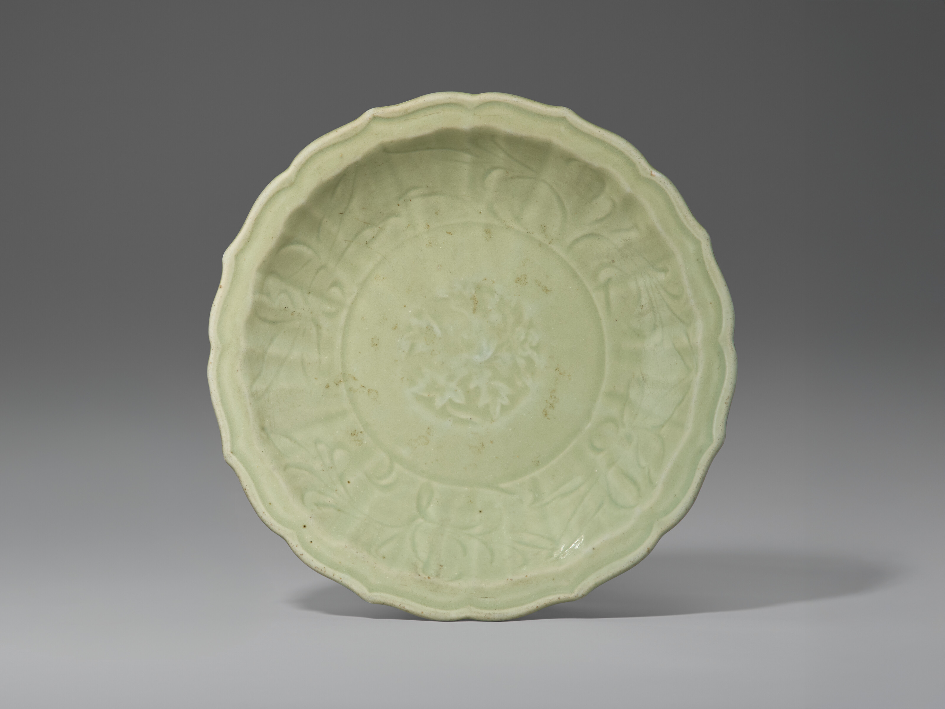 A CARVED LONGQUAN CELADON DISH WITH BARBED RIM