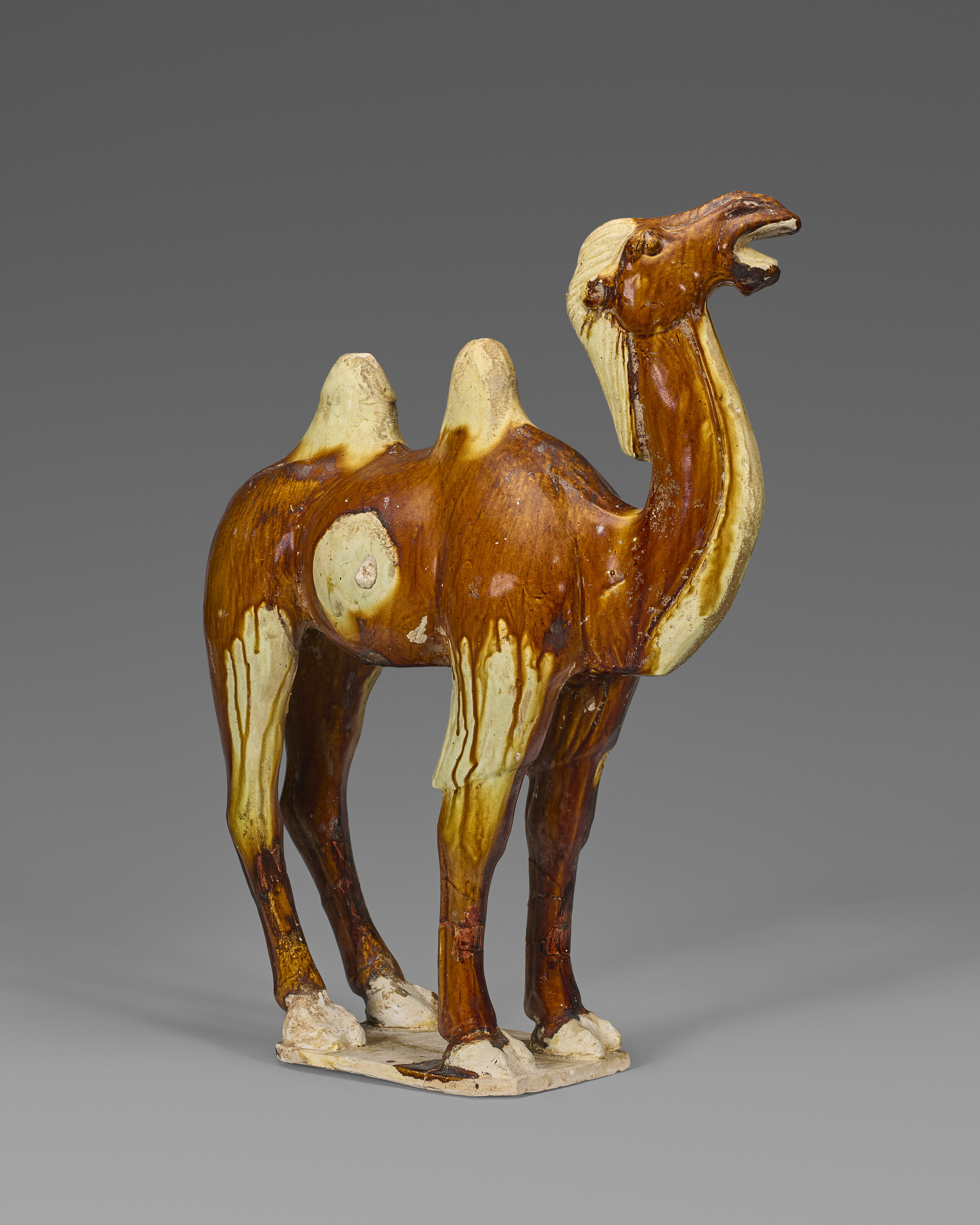 A LARGE AMBER AND CREAM-GLAZED POTTERY FIGURE OF A BACTRIAN CAMEL