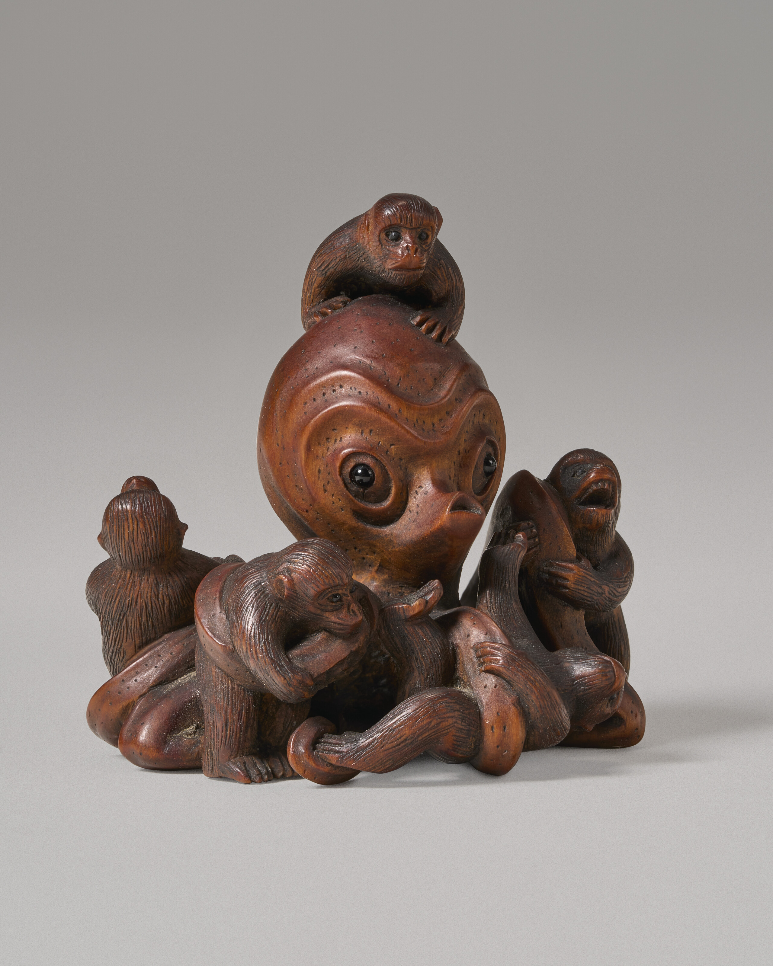A CARVED WOOD MINIATURE SCULPTURE (NETSUKE) OF OCTOPUS AND MONKEYS