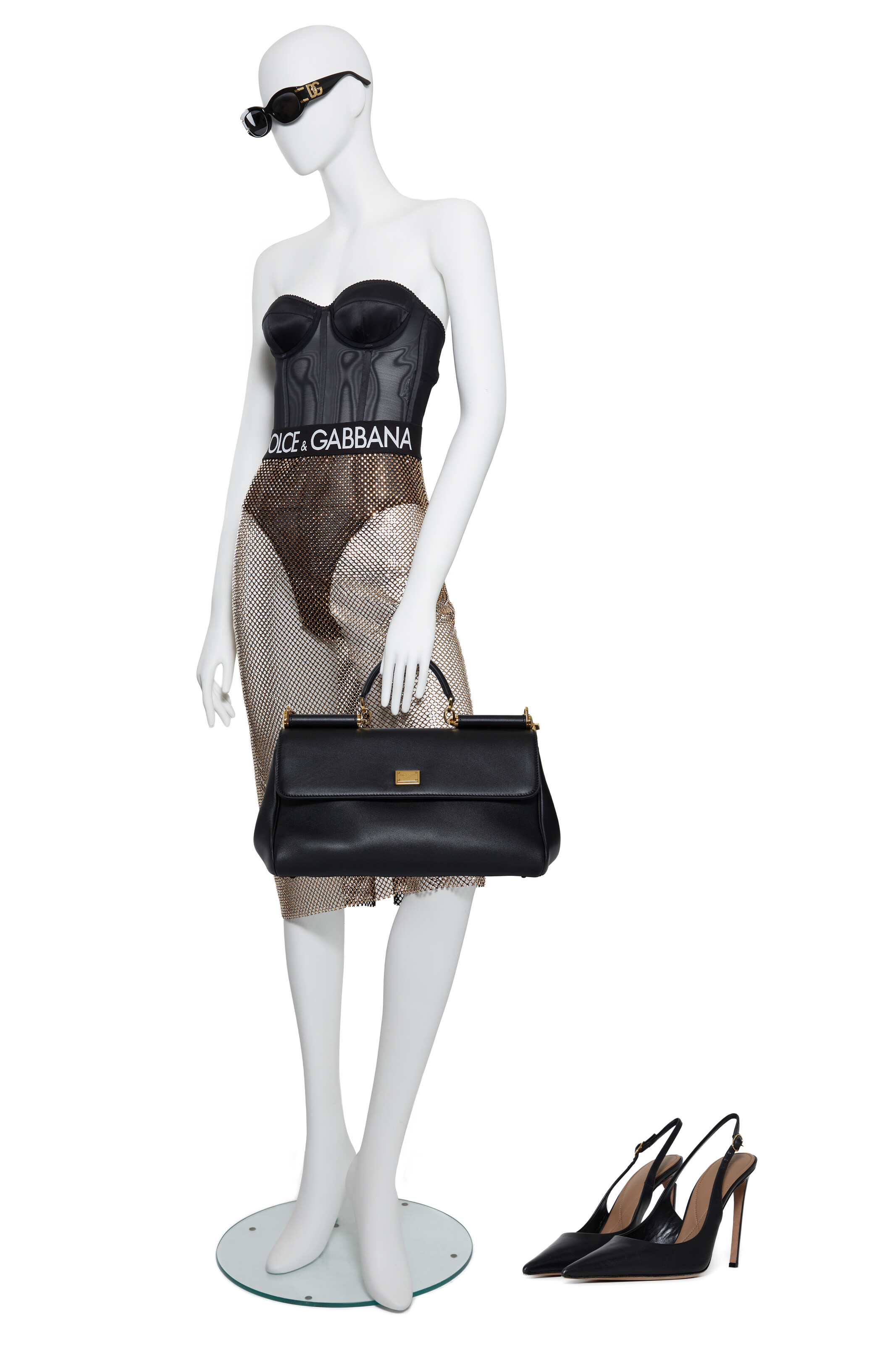 A CORSETED BODYSUIT, SHEER RHINESTONE MESH SKIRT, BLACK SUNGLASSES, BLACK LEATHER PUMPS & BLACK 'MY SICILY TOP HANDLE BAG', SCREEN WORN BY SIMONE ASHLEY