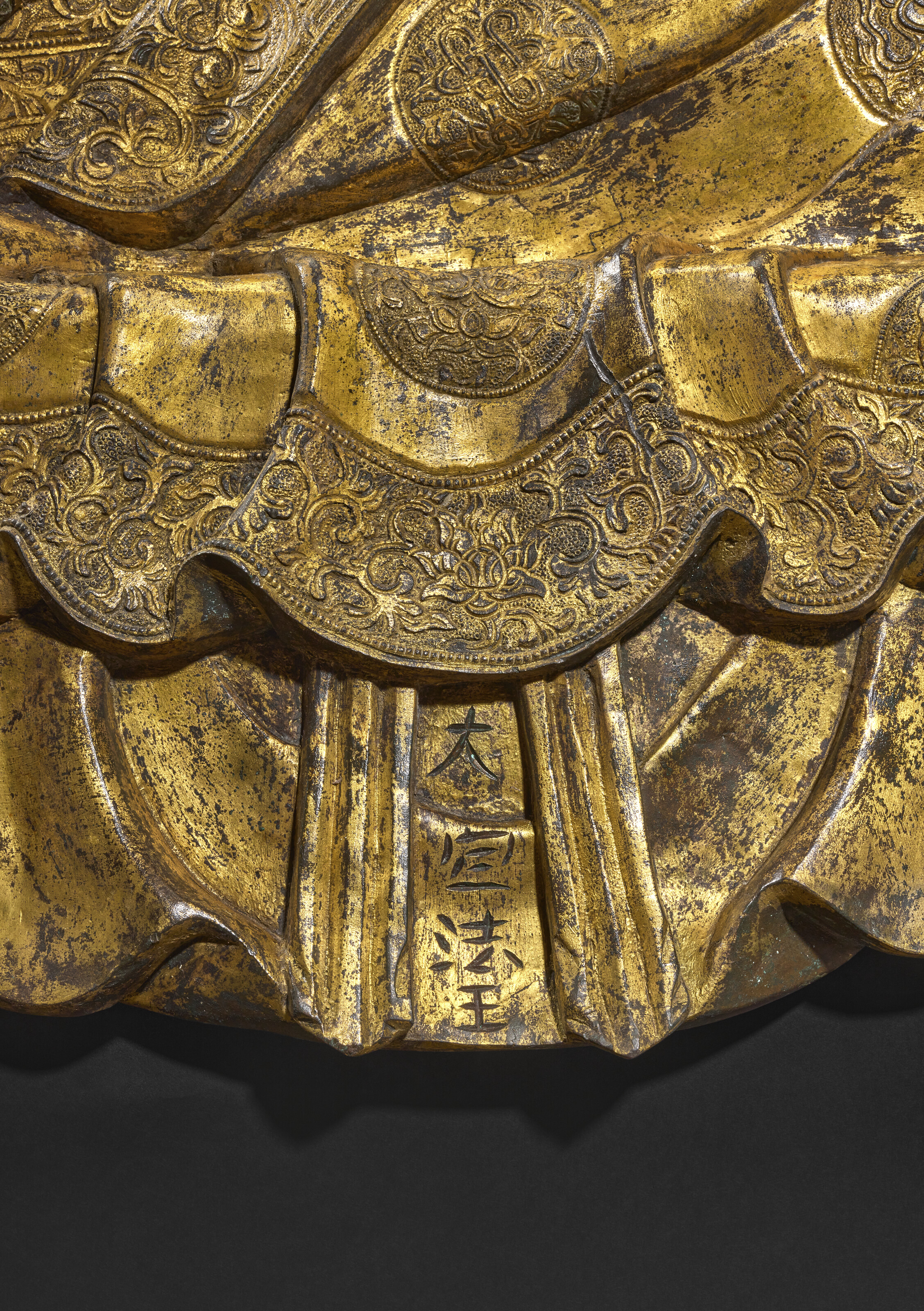 The figure has a vertically chiselled Chinese inscription reading 'Great Precious Dharma King', explicitly identifying the subject of the sculpture. The title indicates the elevated status of the figure represented in the hierarchy of Tibetan Buddhism and underscores the close ties between the Ming emperors and the Karmapa lineage
