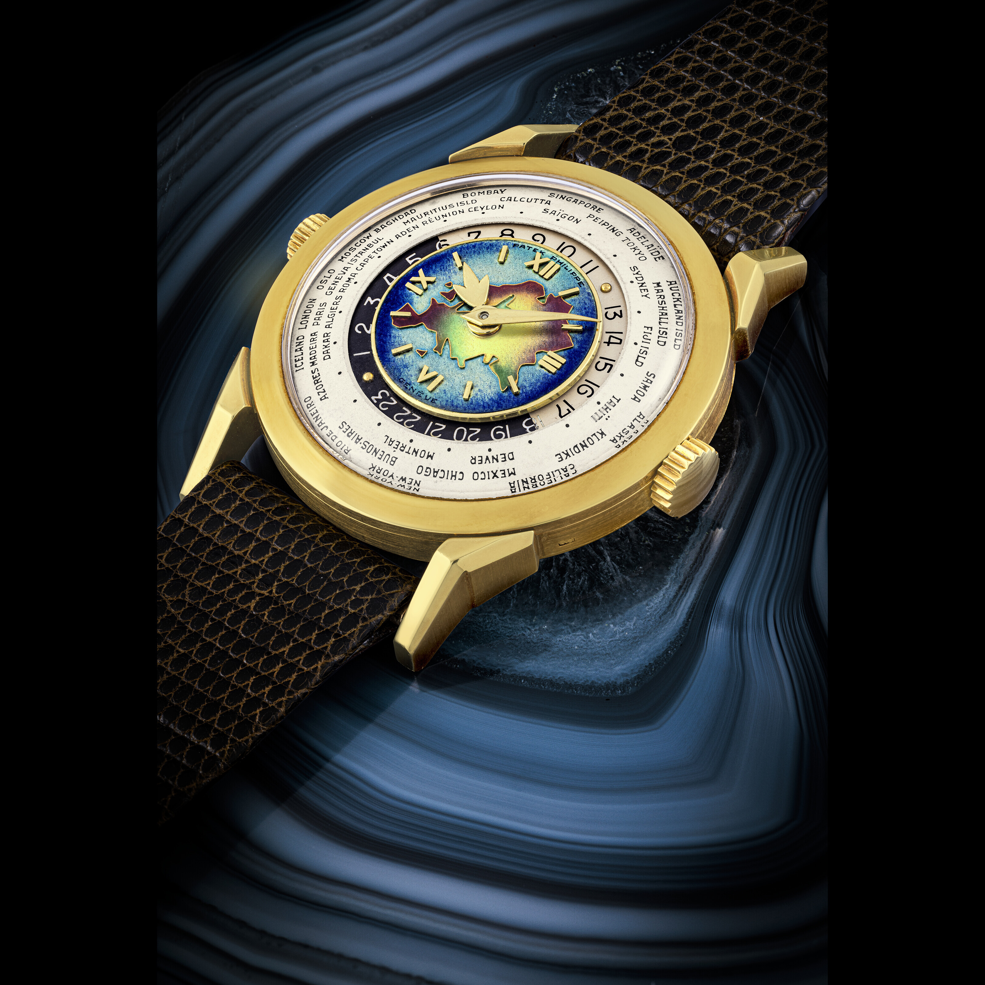 PATEK PHILIPPE. AN EXCEPTIONAL HIGHLY IMPORTANT AND EXTREMELY RARE 18K GOLD TWO CROWN WORLD TIME WRISTWATCH WITH 24 HOUR INDICATION AND CLOISONNE ENAMEL DIAL DEPICTING THE EURASIA MAP Christie s