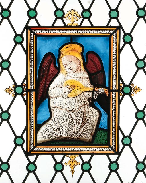 A RECTANGULAR STAINED GLASS PANEL OF A MUSIC-MAKING ANGEL